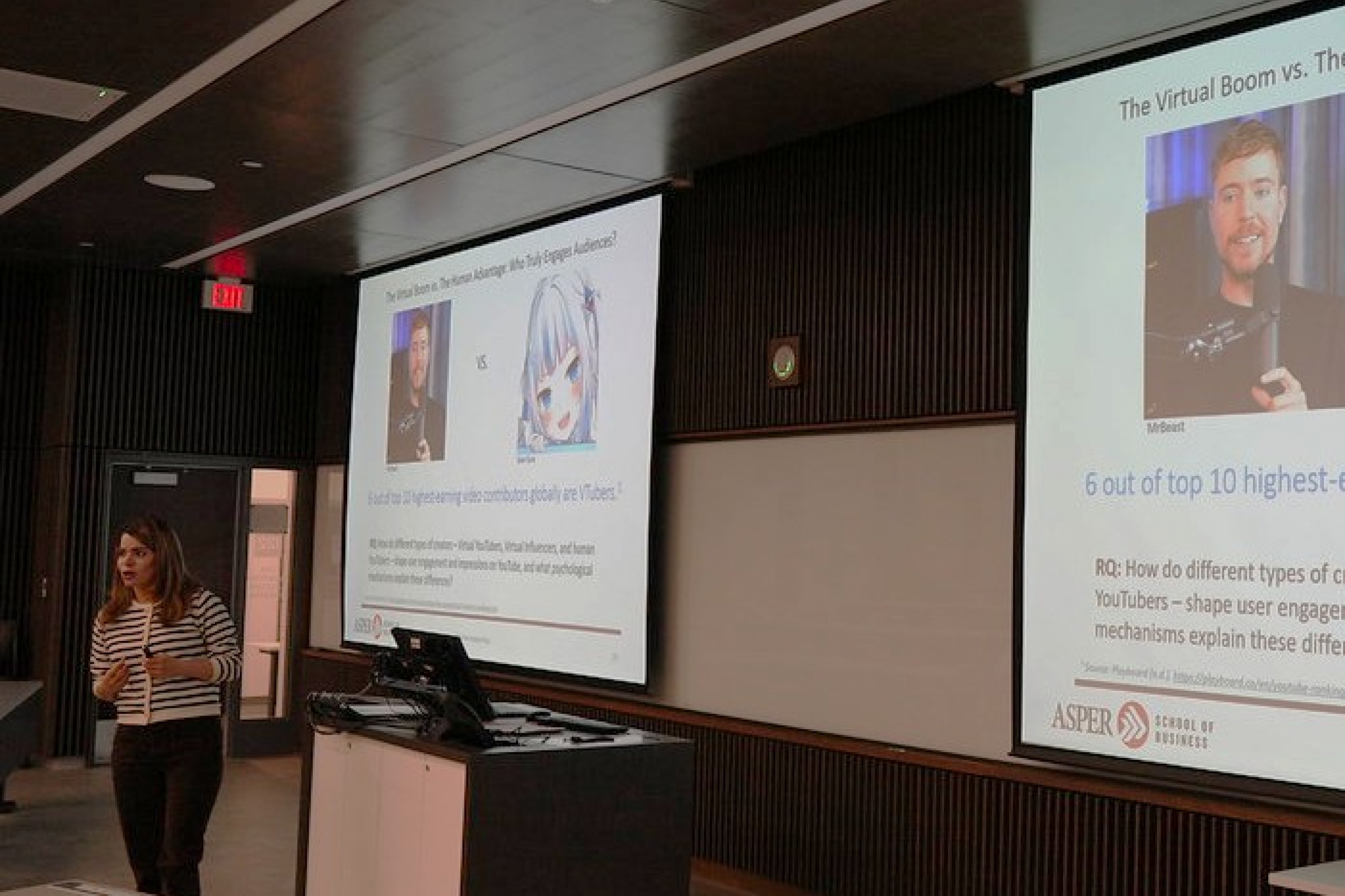 A professor gives a lecture at the front of a classroom