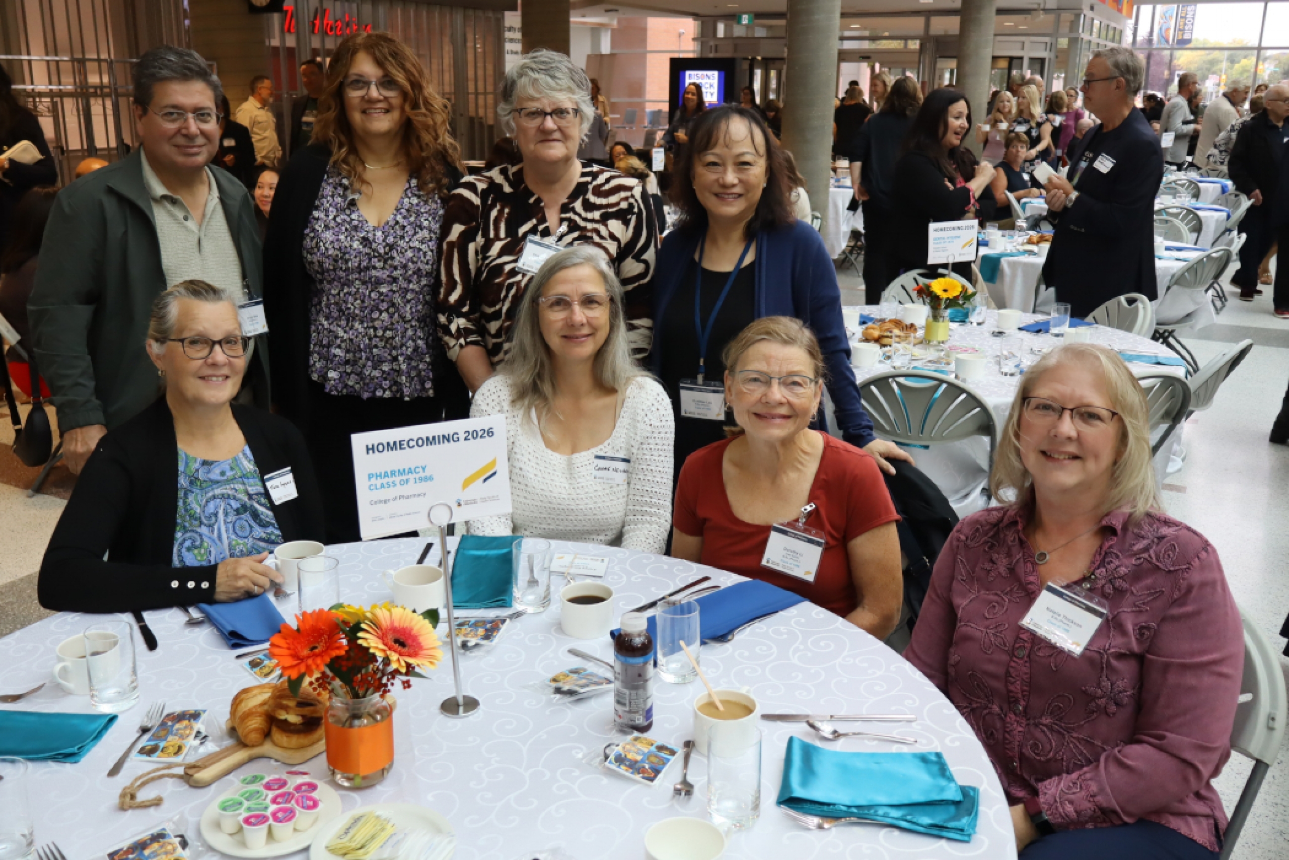 Eight alumni from the Pharmacy Class of 1986 pose for a photo. 