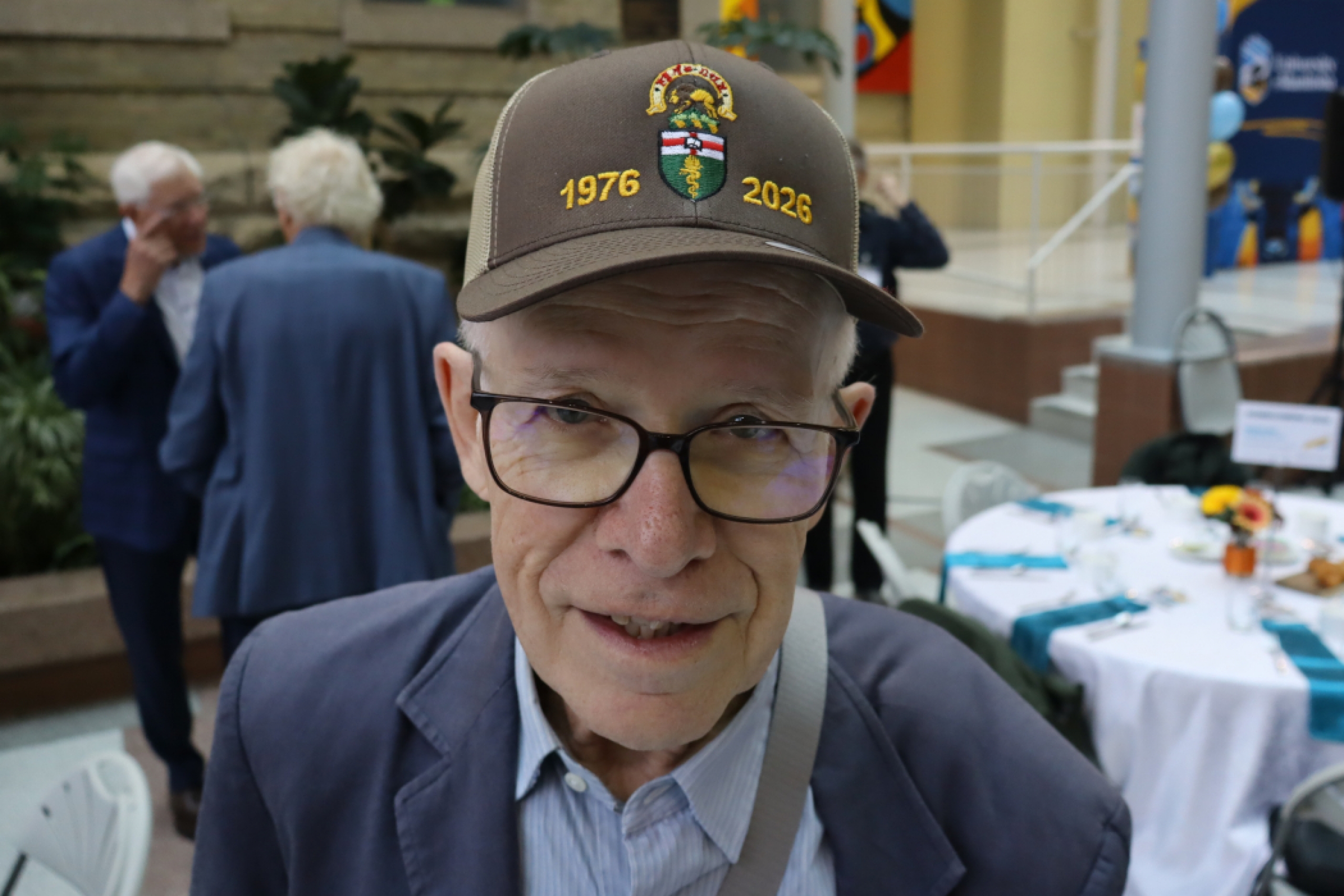 Medicine alum is wearing a Class of 1976 hat. 