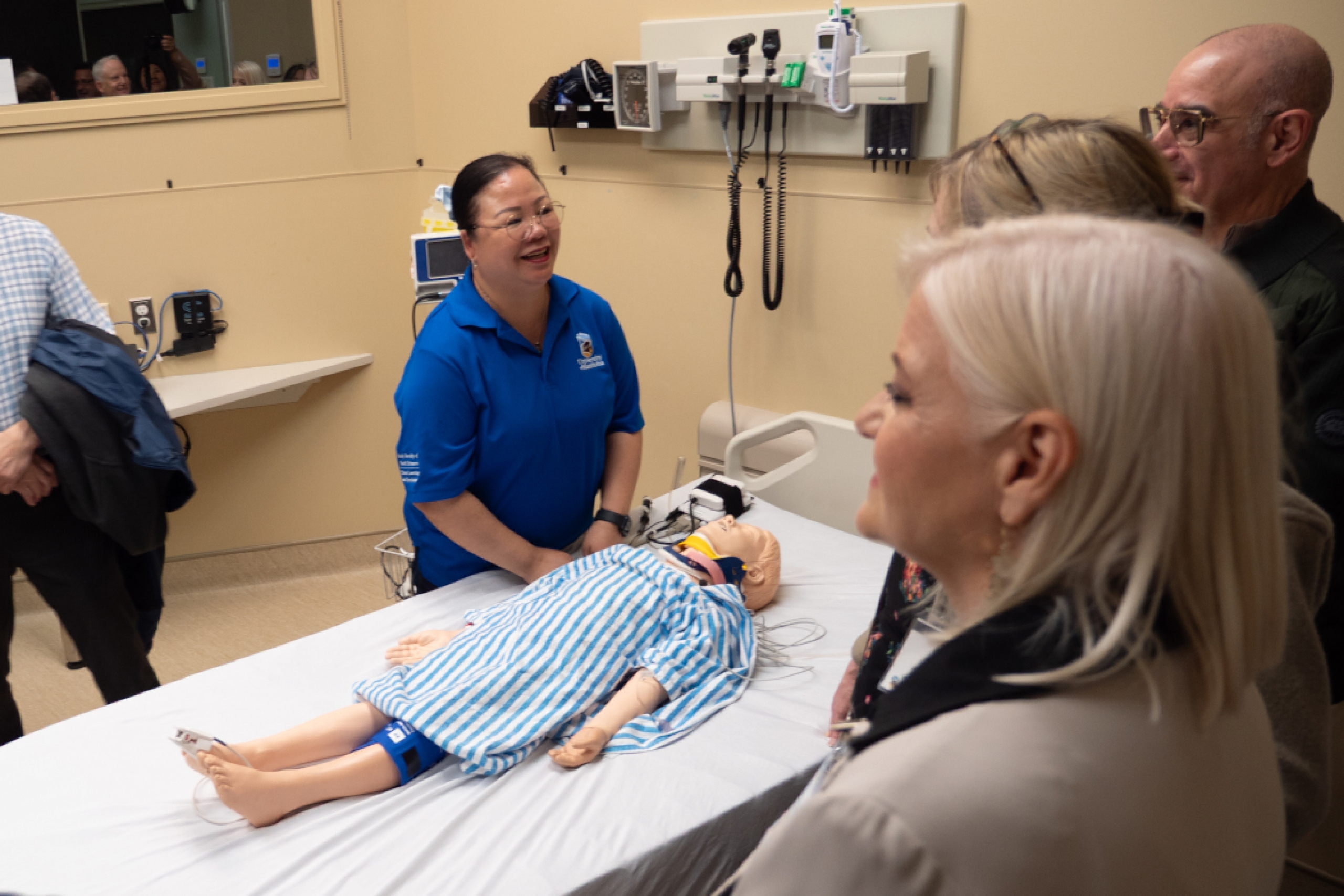 A staff member demonstrates a training manikin. 