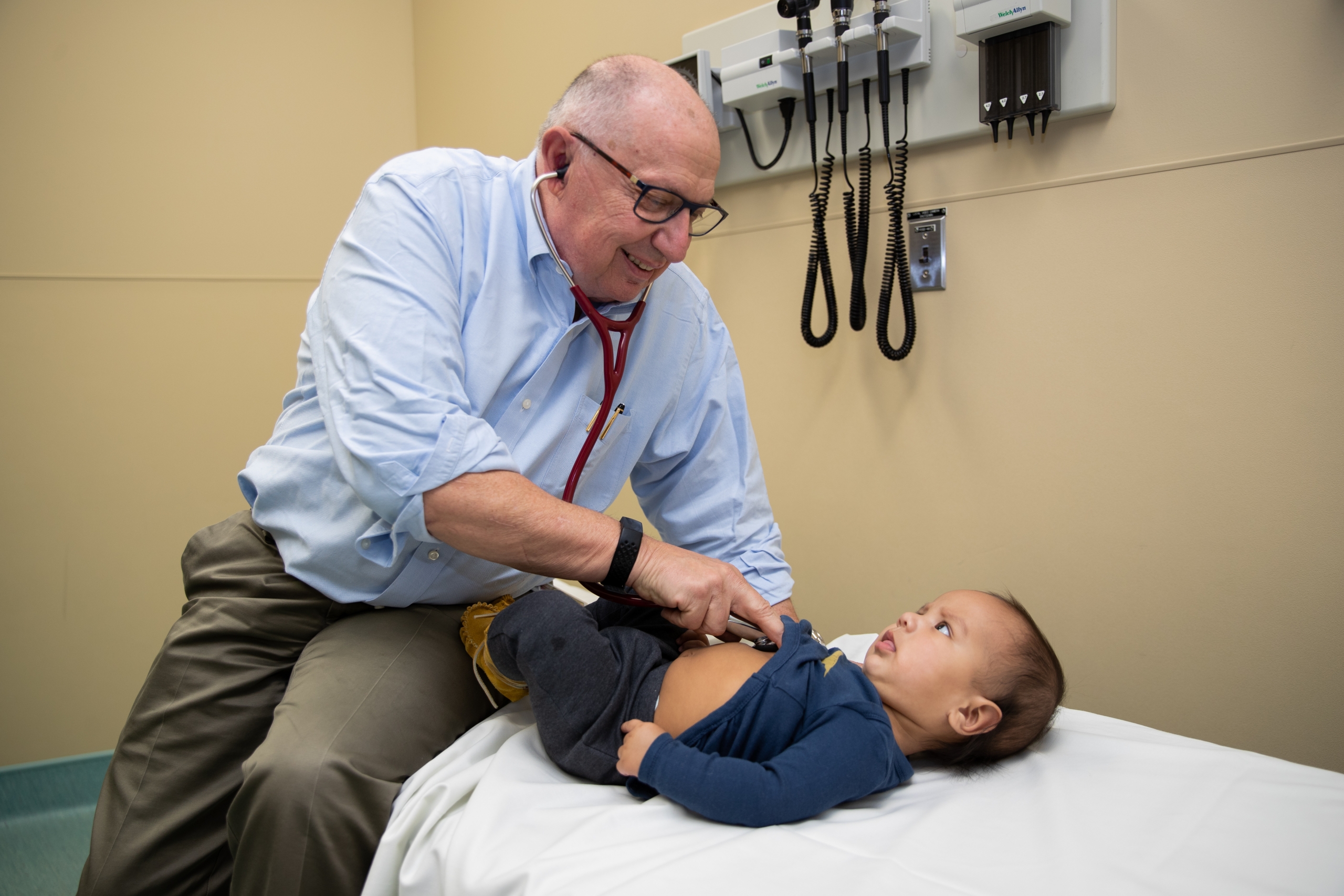 Dr. Brian Postl and a child in an examination room. 