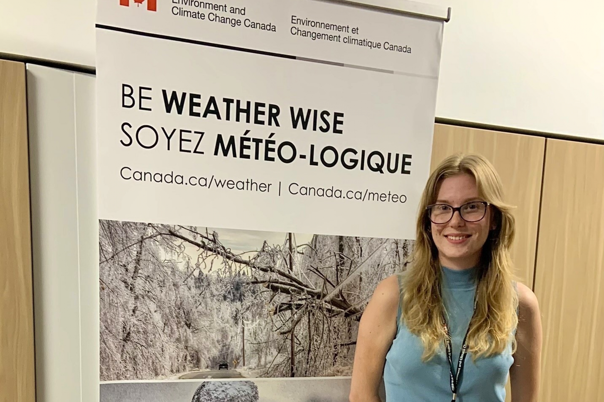 Abby Procter standing in front of a pop-up banner for Environment Canada.