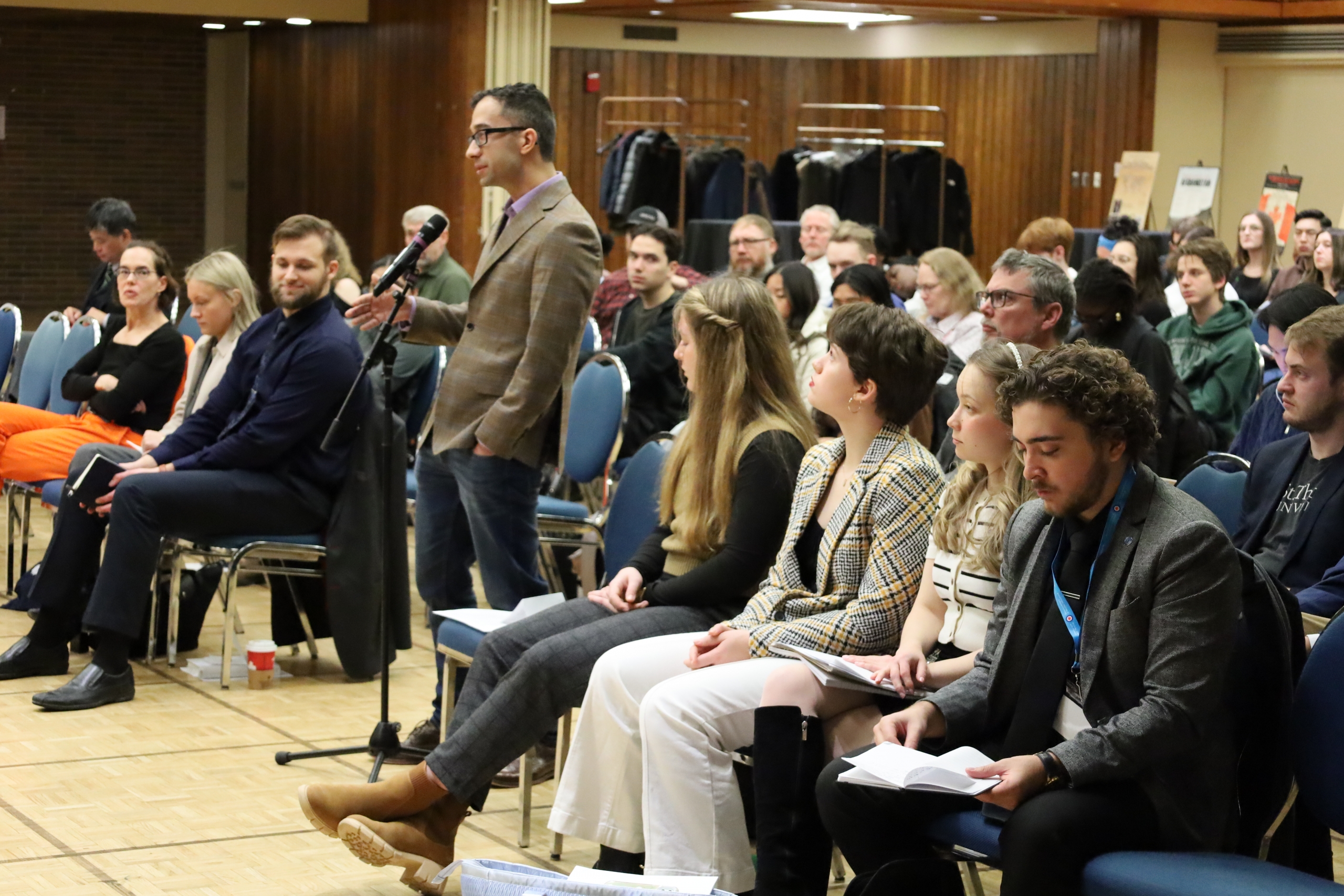 An audience member standing at the microphone asking the panel a question.