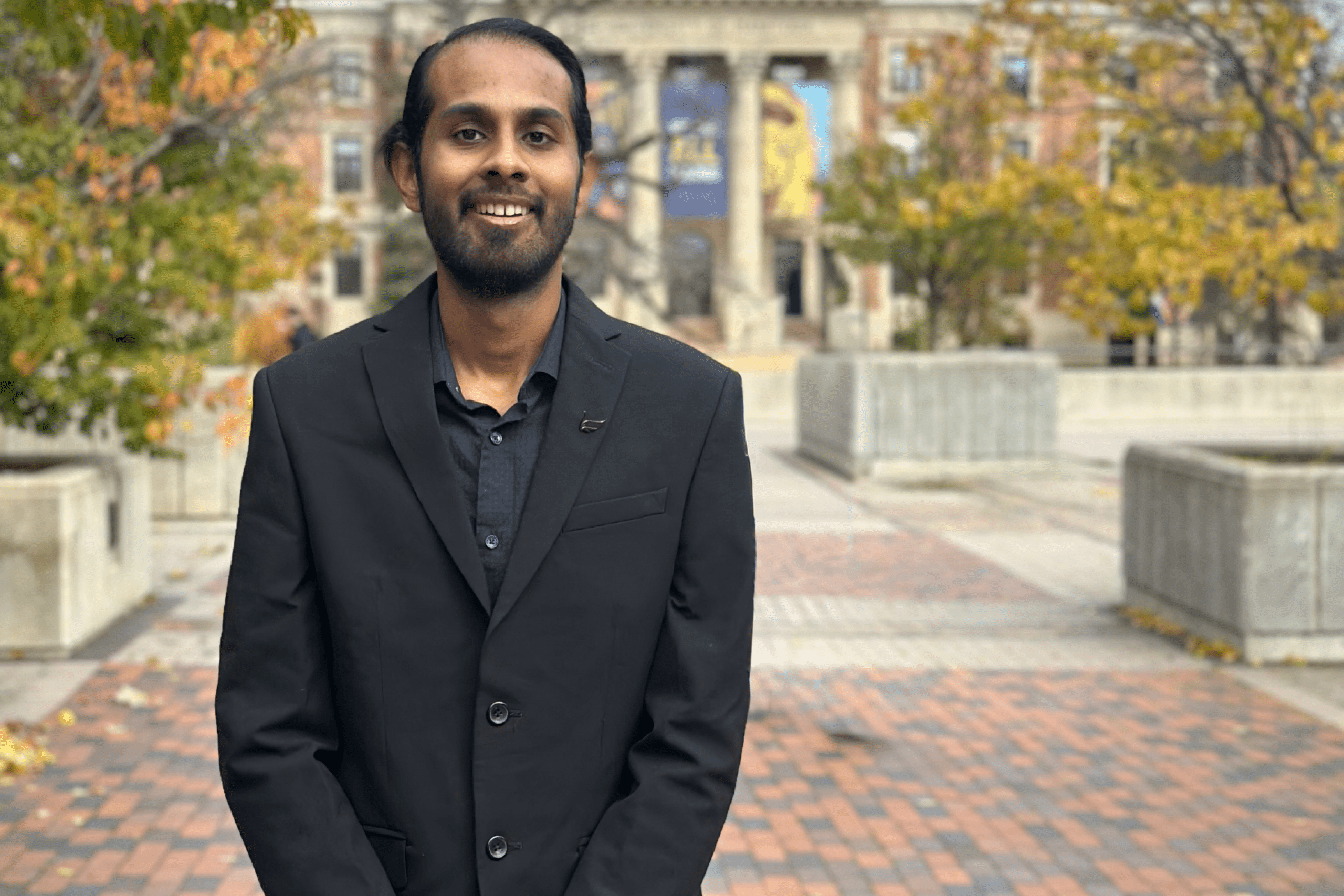 Student stands before path to UM admin building