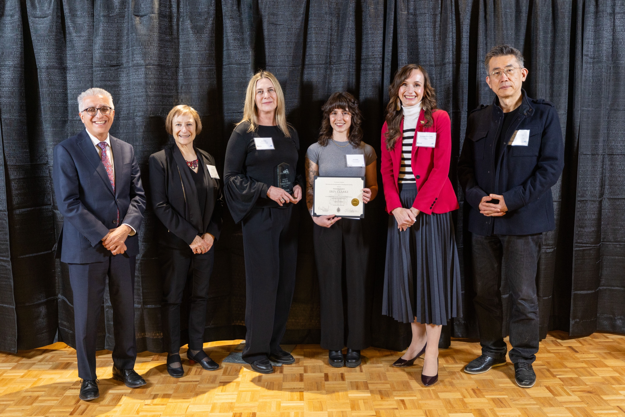 Erin Clarke holds her award in a group photo with her past educators.