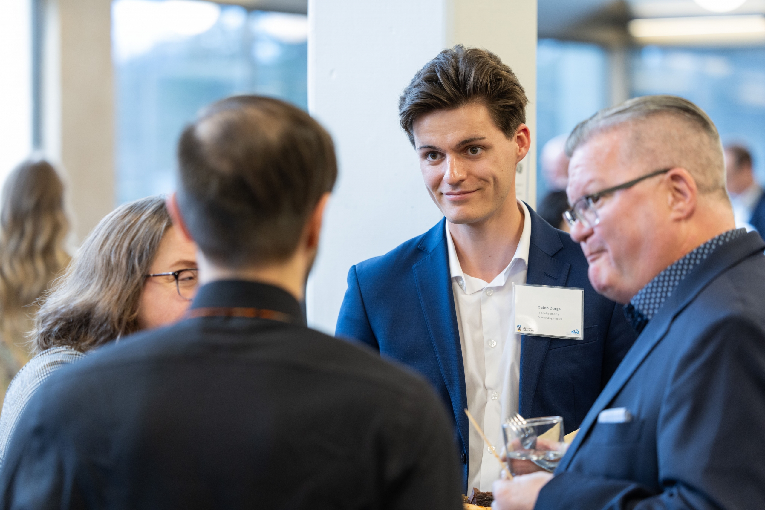 Caleb Dorge engages in conversation during the reception.