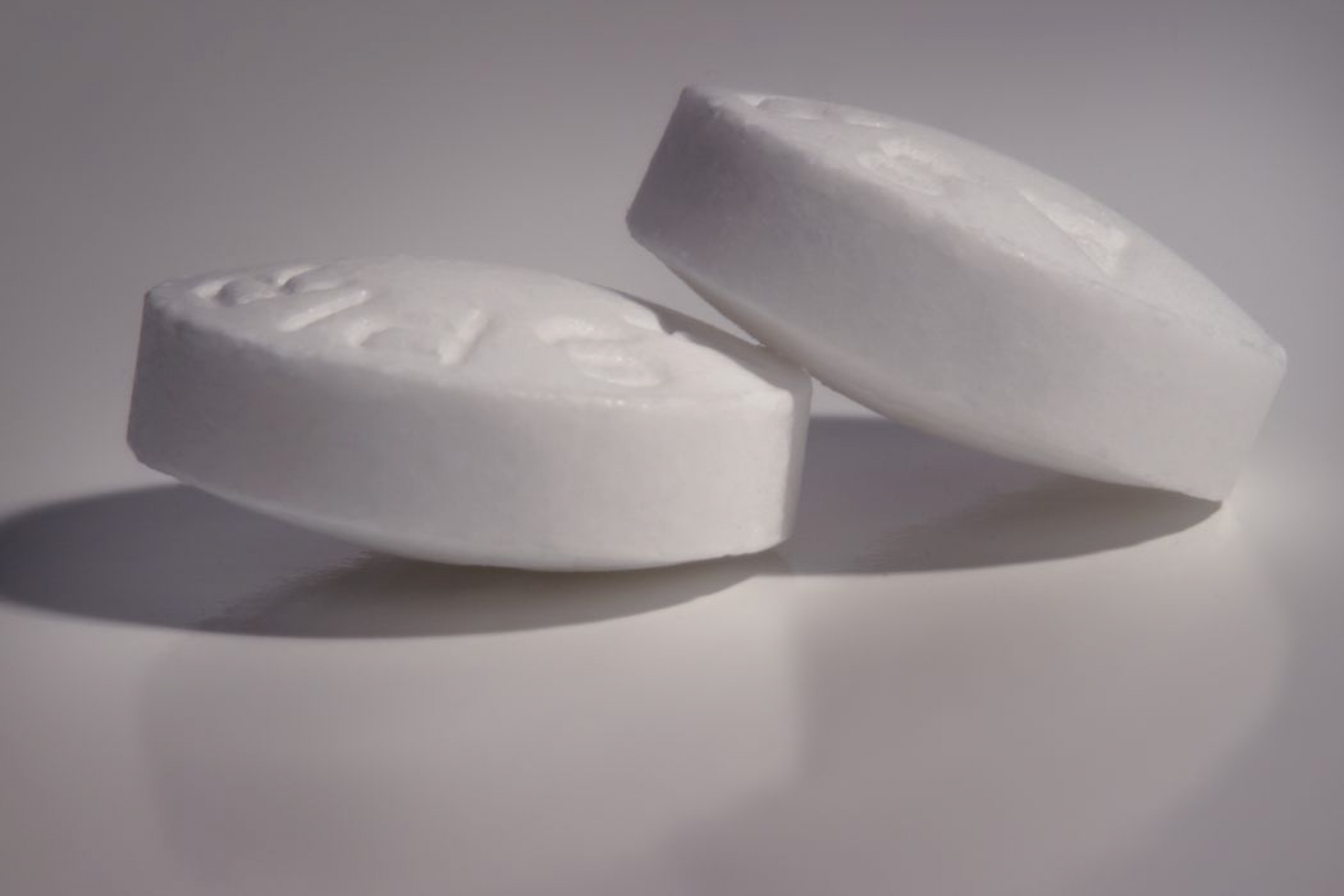 Close up of two aspirin pills. 