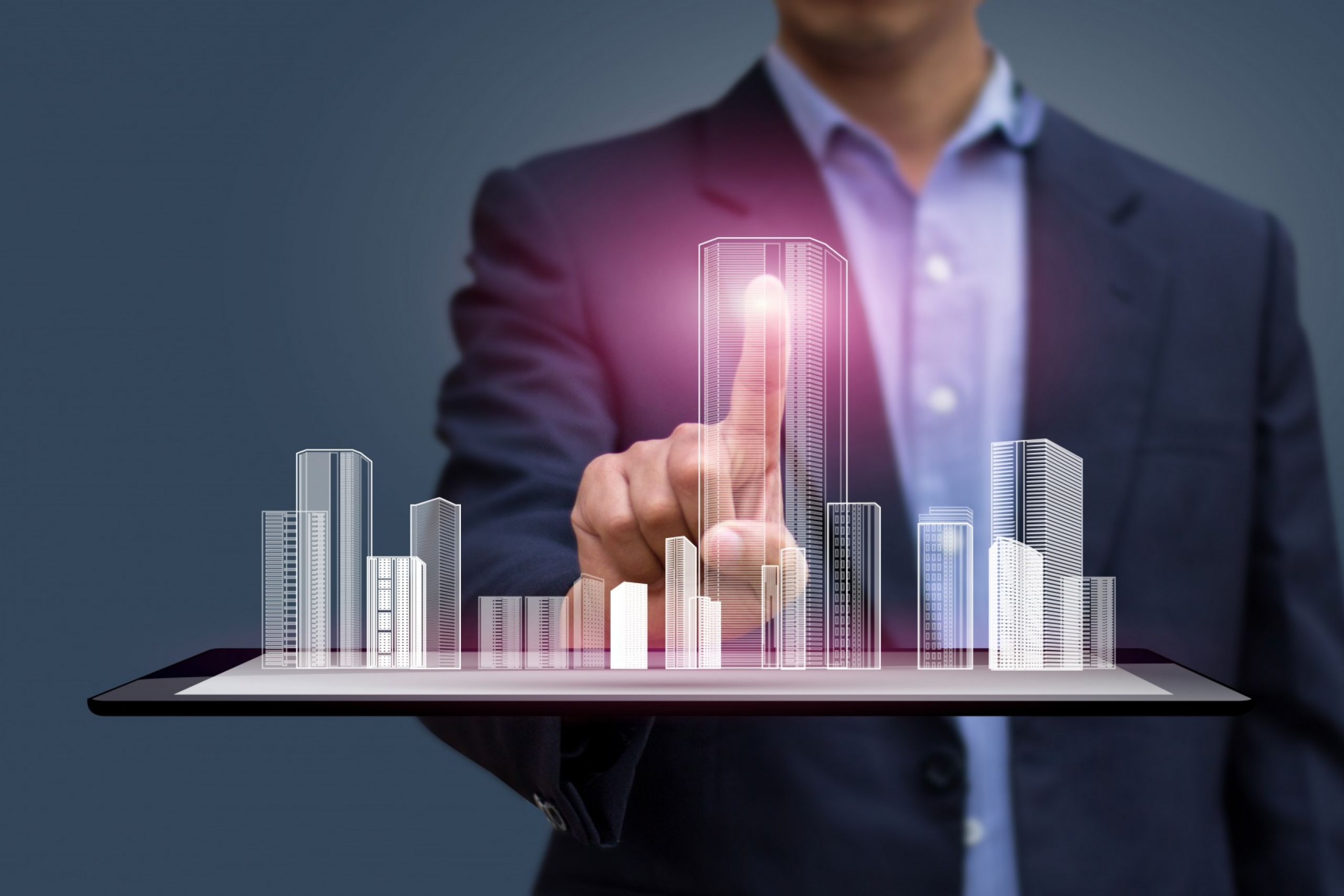 Man in suit holds digital buildings 