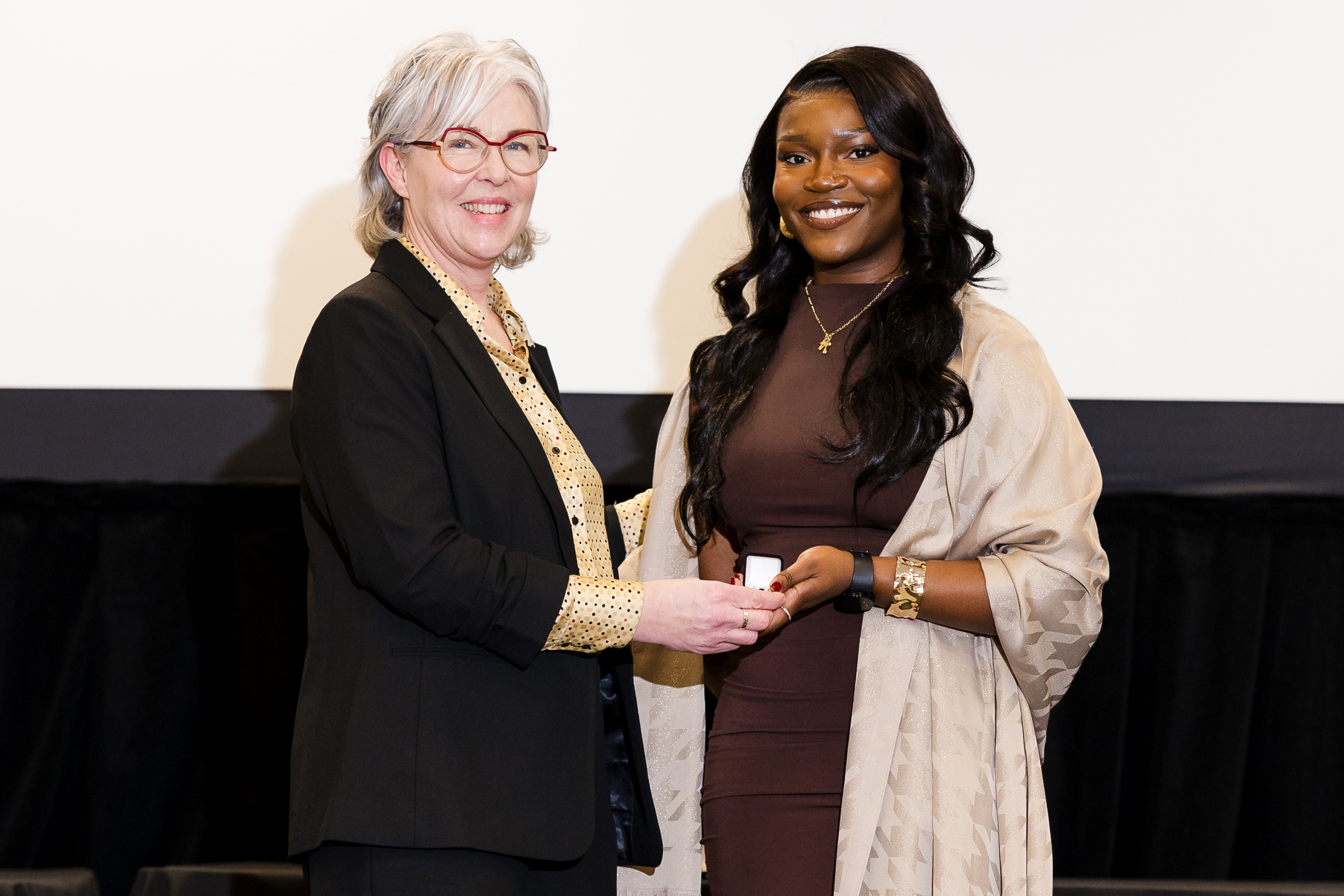 IniOluwa Odimayomi receives her nursing pin from Dr. Kellie Thiessen.