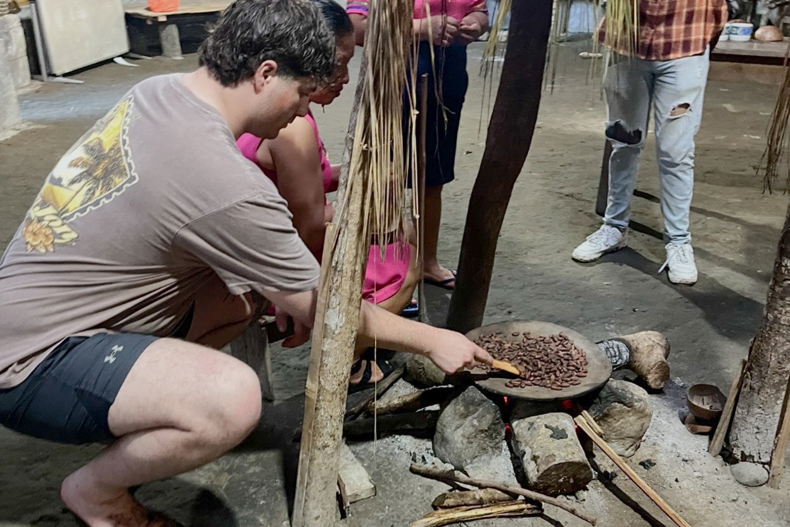 A person roasting coffee beans on a fire.
