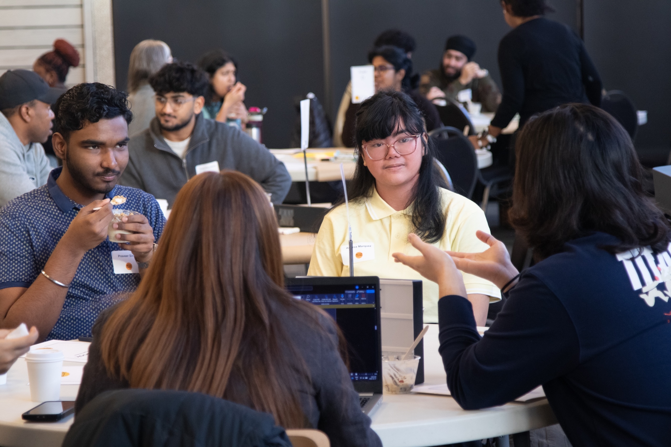 Four students sitting at a table and talking.