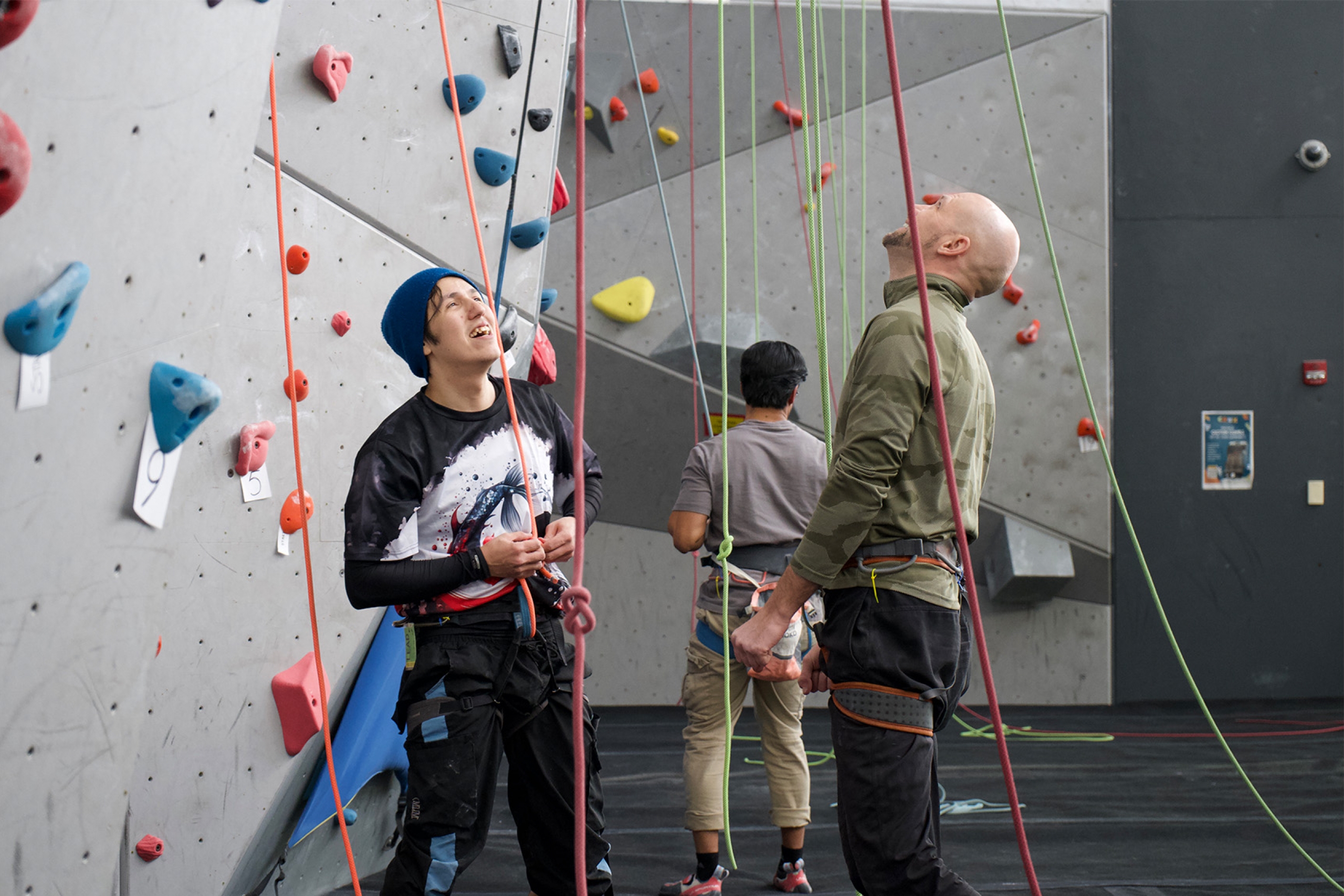 Two climbers looking up at the climbing wall and smiling