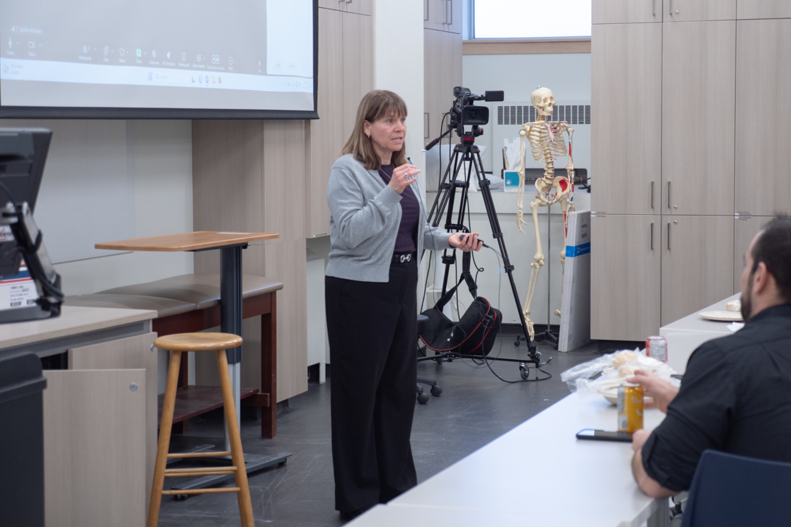 A person talking in front of a classroom.