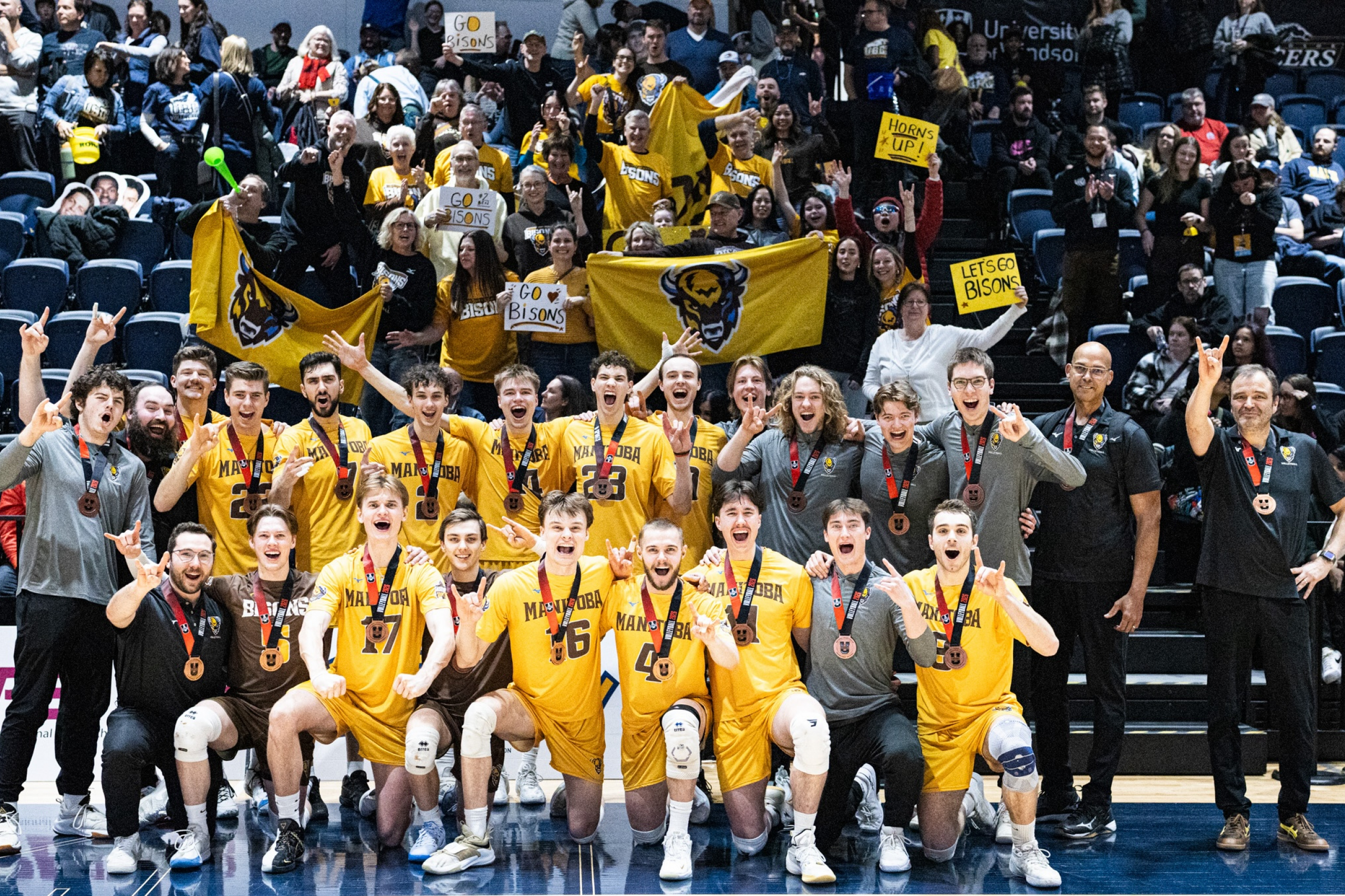 The UM bisons men's volleyball team celebrating together with their silver medals