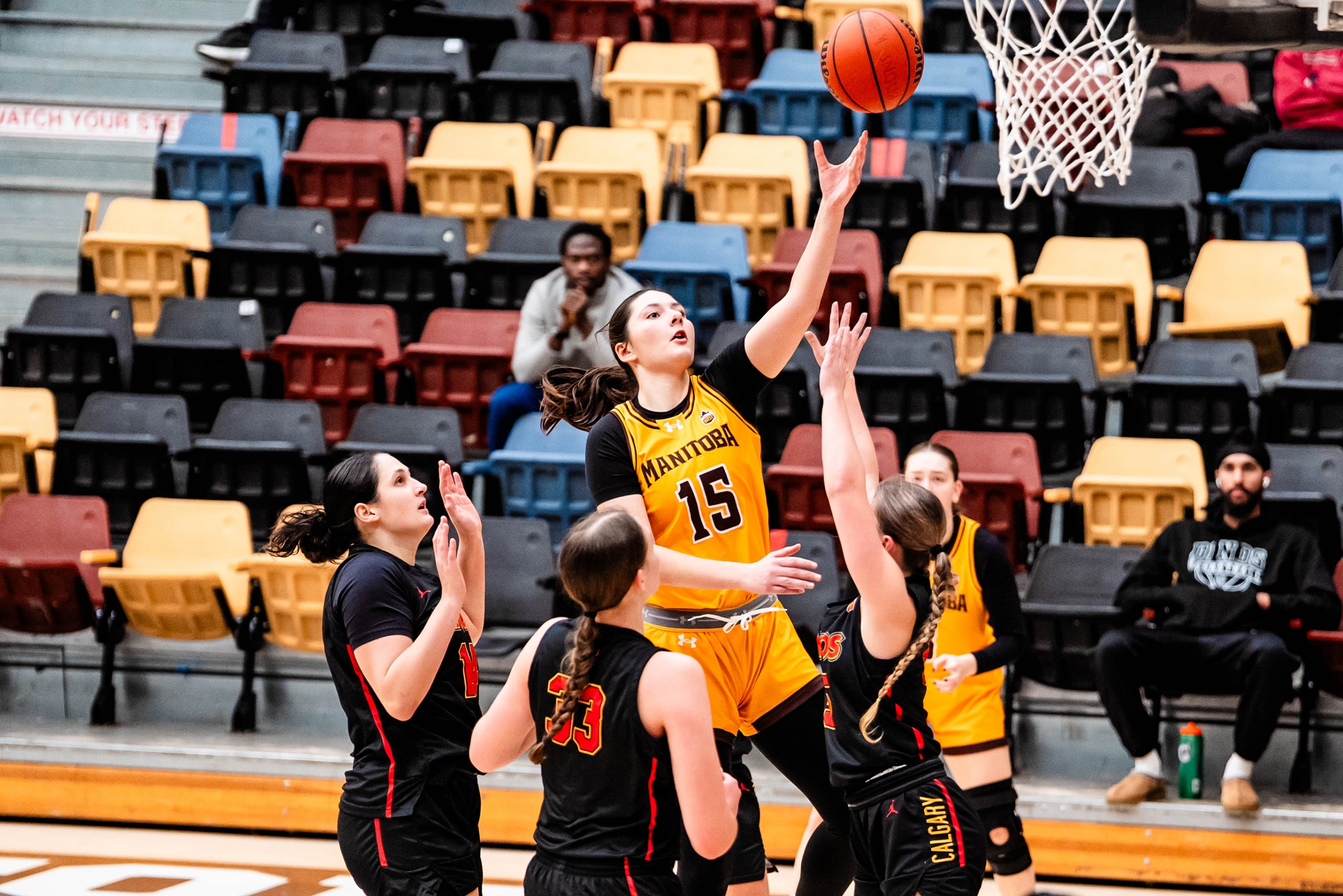 A Bisons women's basketball player going for a layout surrounded by opponents