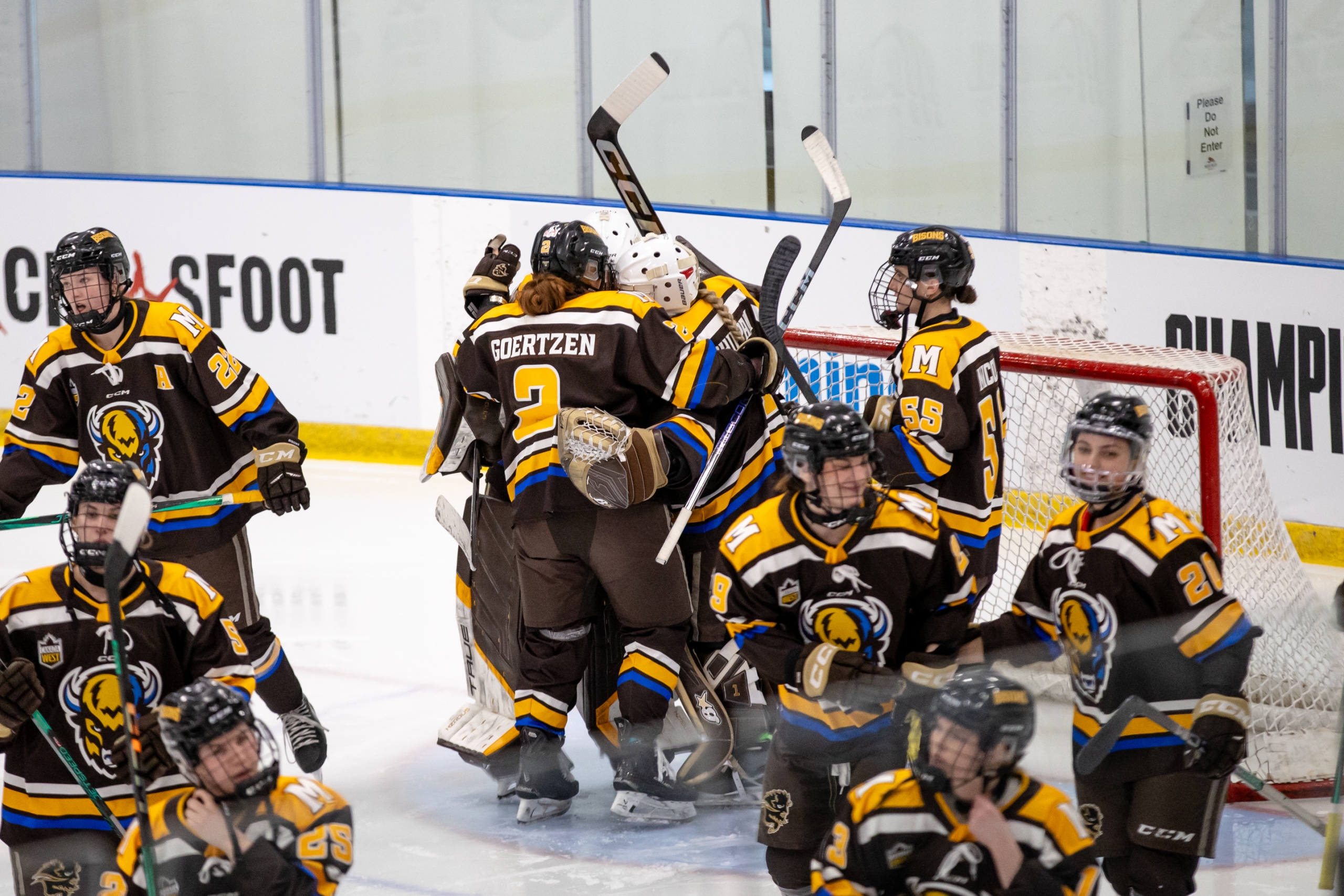 The Bisons women's hockey team celebrating together on the ice