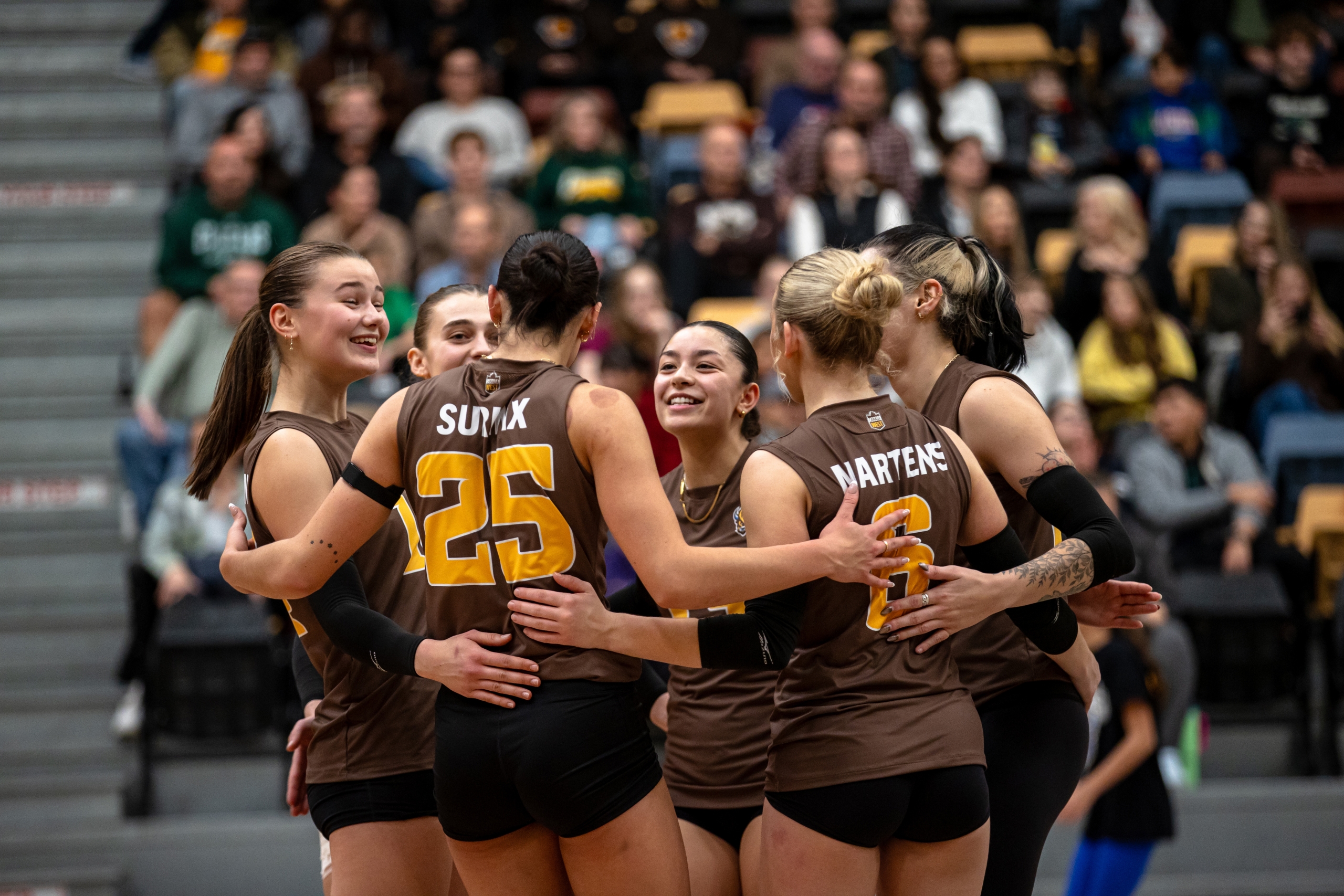 Women's volleyball players celebrating after a point