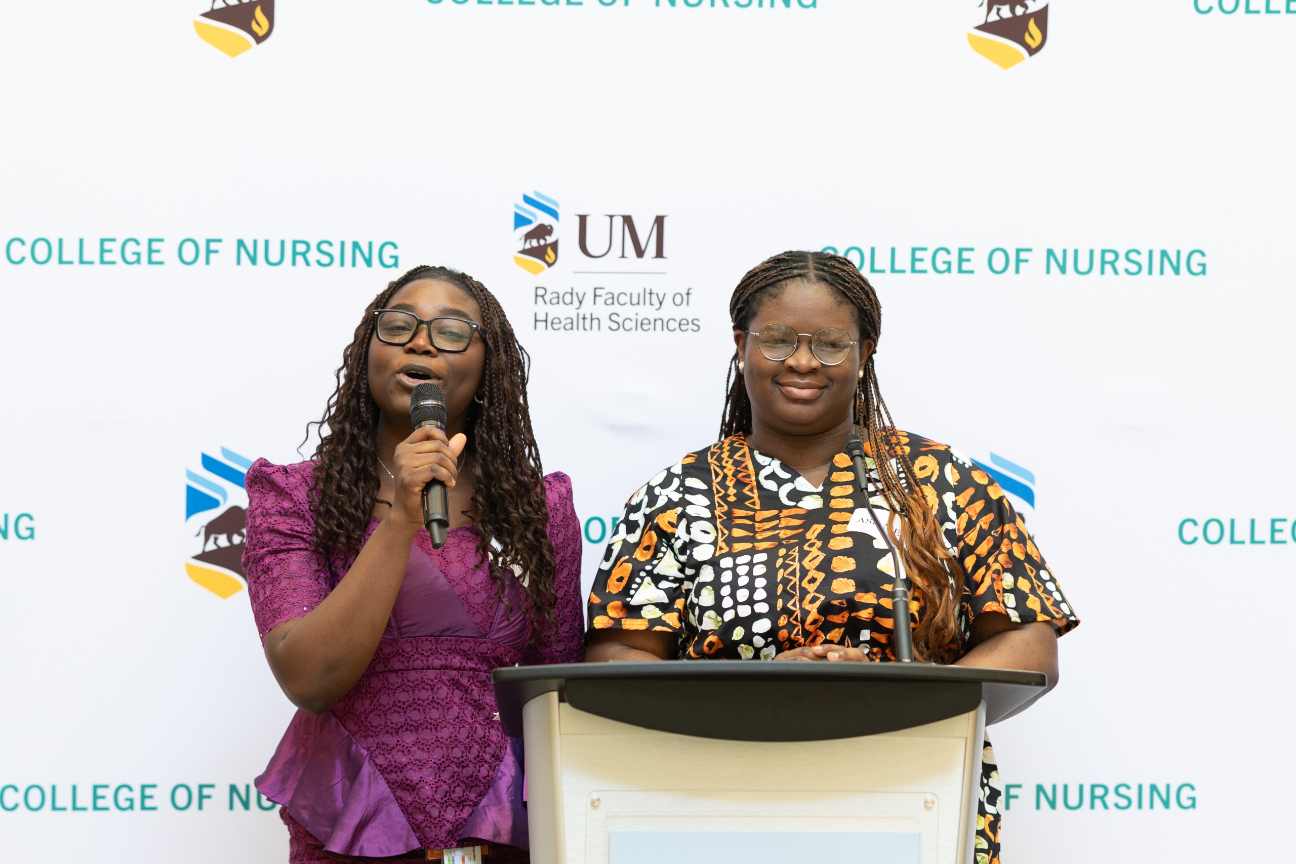 Emcees for the College of Nursing's Black History Month event, Tolani Olanrewaju and Oluwatomiloba (Tomi) Oyewusi, speak at a podium.