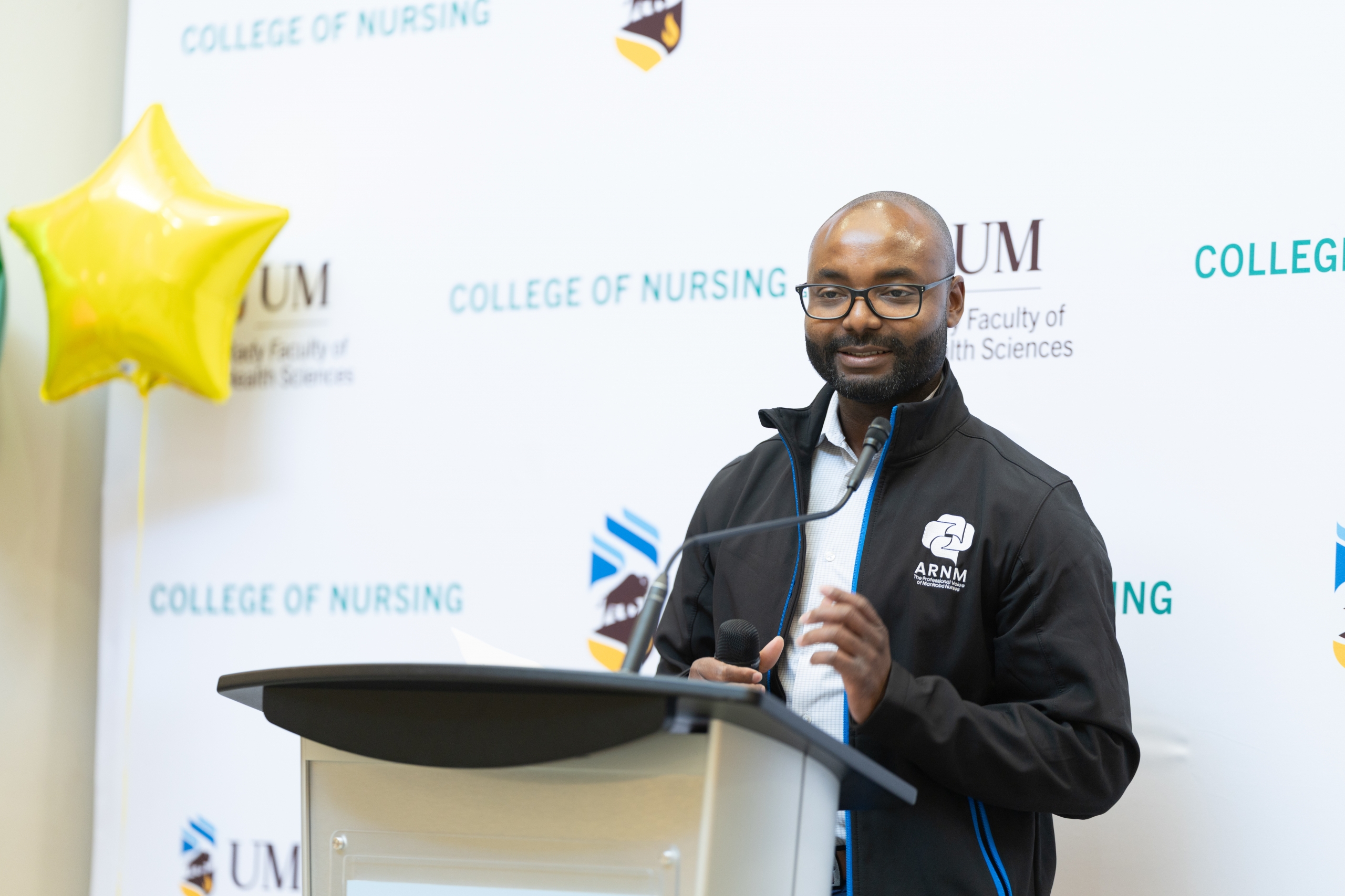 Jacob Ahiaegbe speaks at a podium.