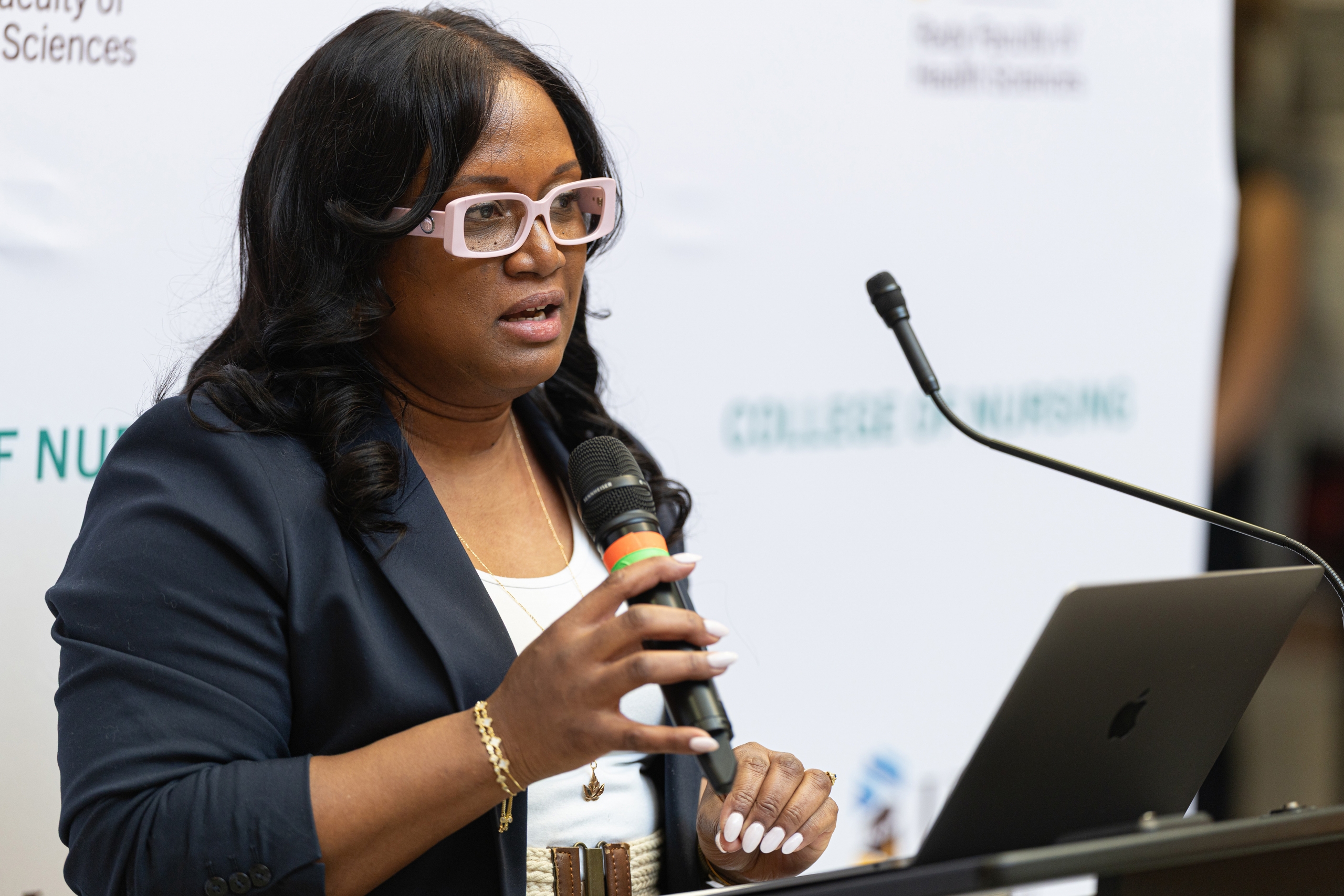 Ava Onwudegwu speaks at a podium.