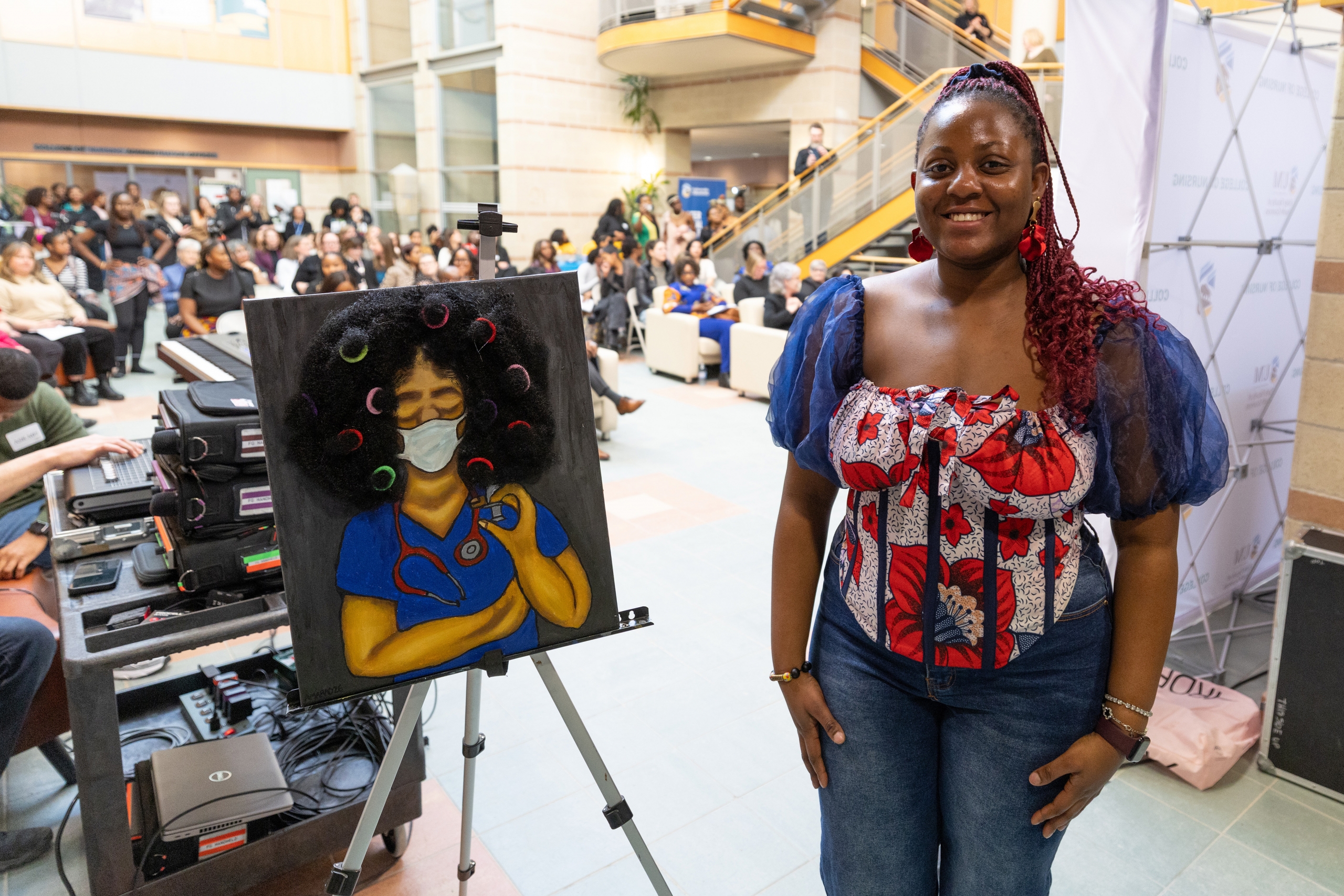 Third-year student Amarachi Ndukauba poses with a painting she created in honour of the celebration. 