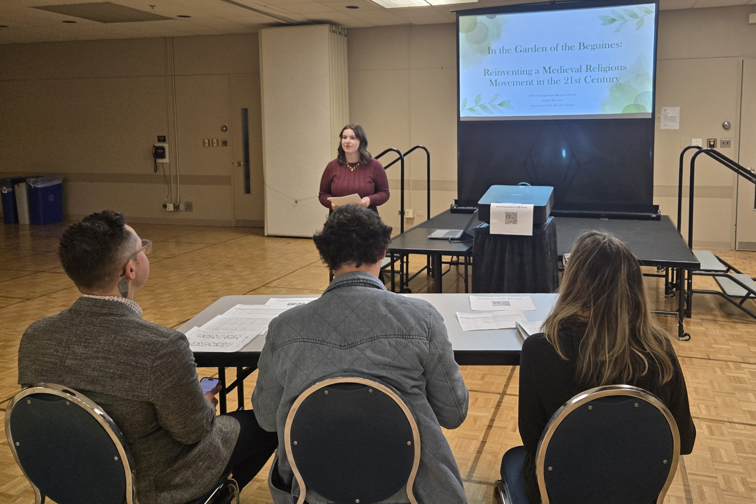 Student delivering presentation to a group of three judges. 
