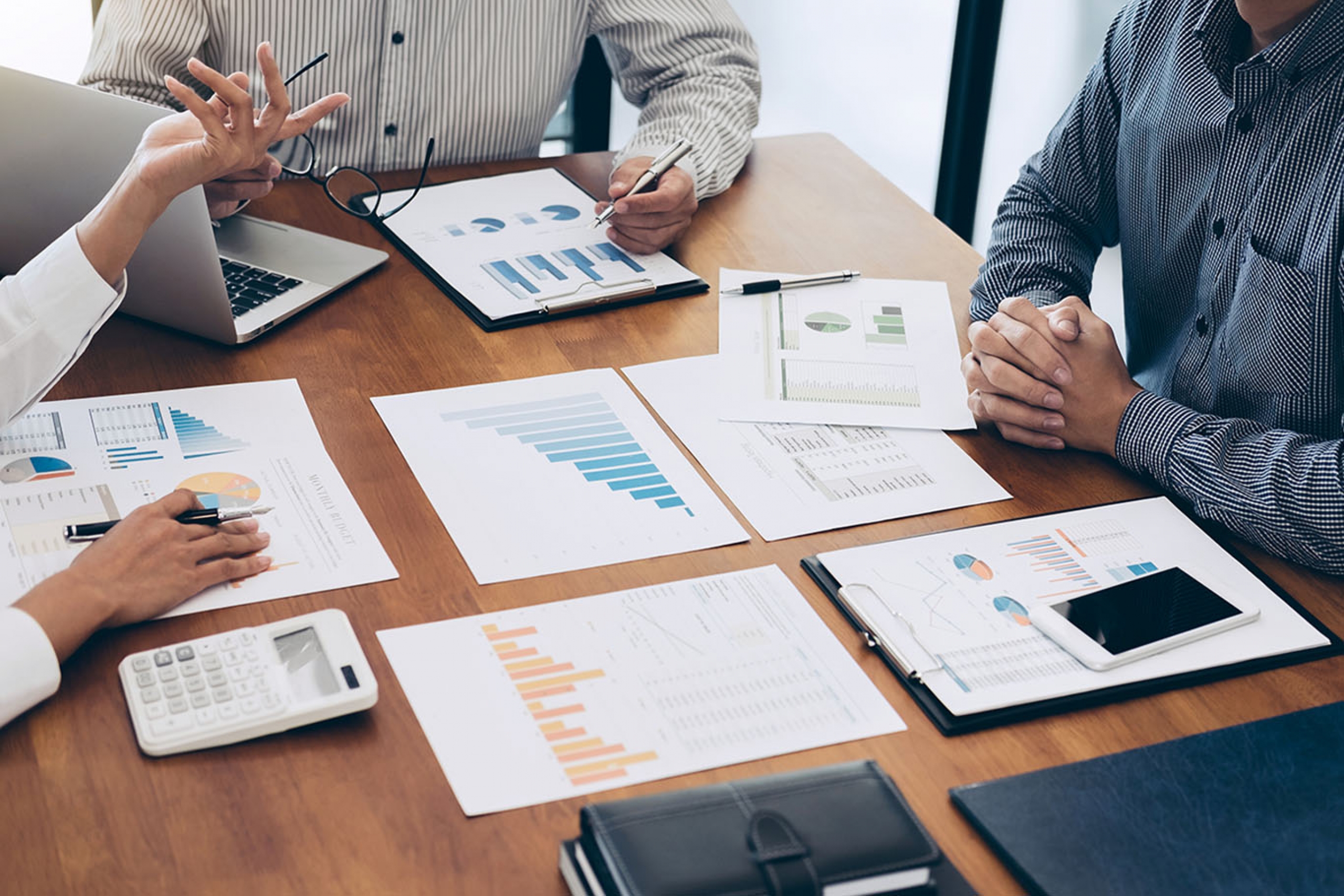 Three people review data at a table