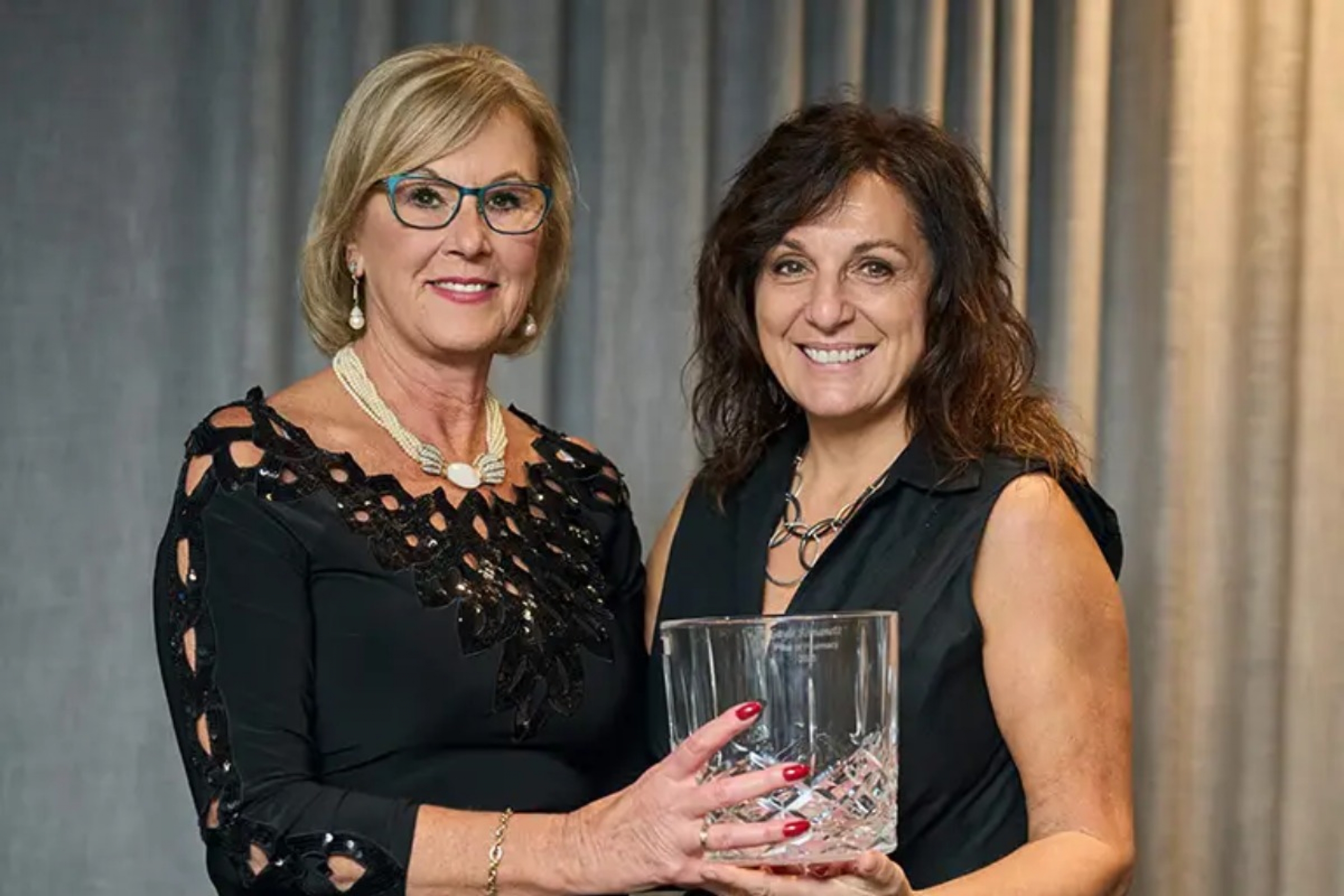 Two people holding an award.