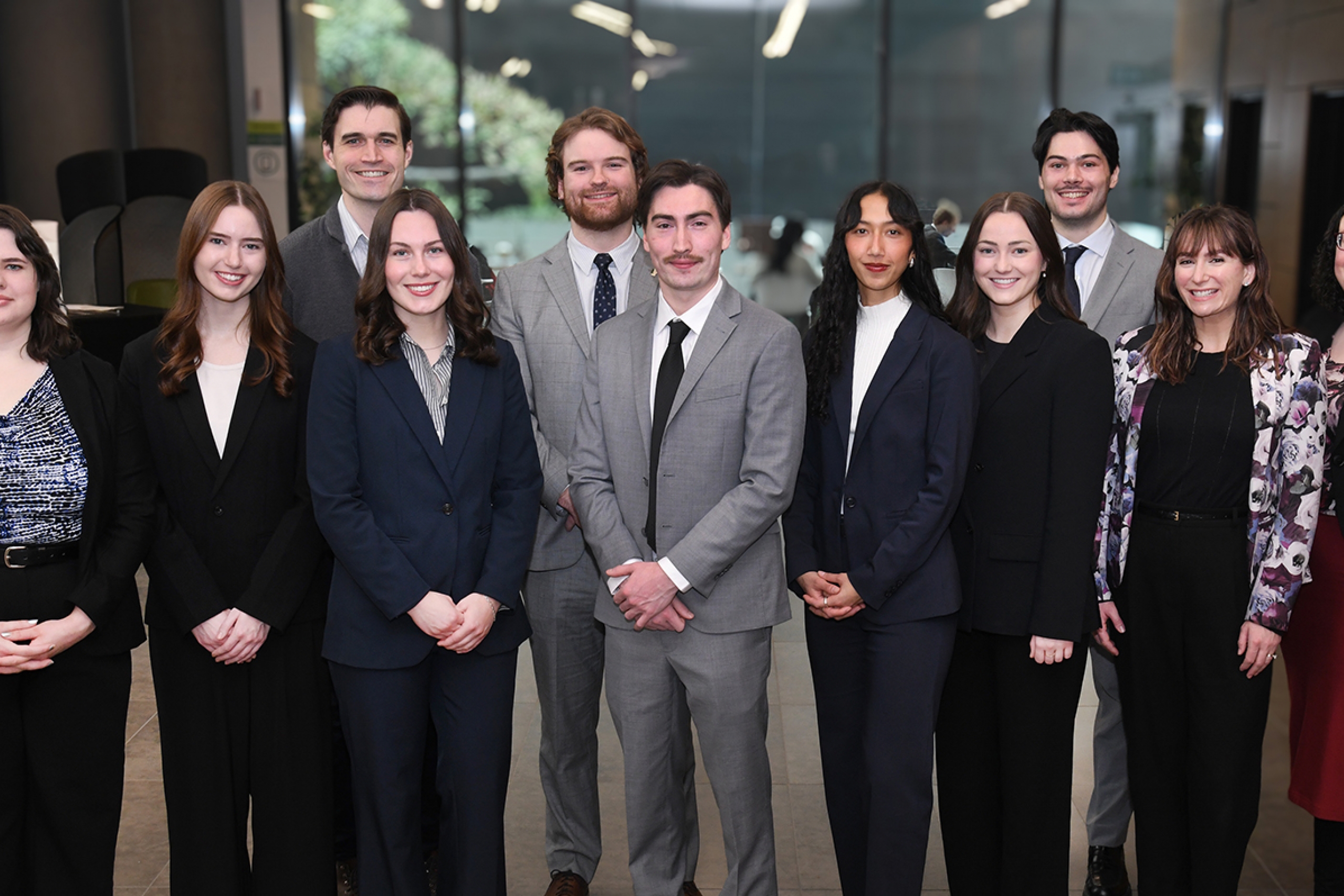 a group of law students and their coaches wear grey and black suits