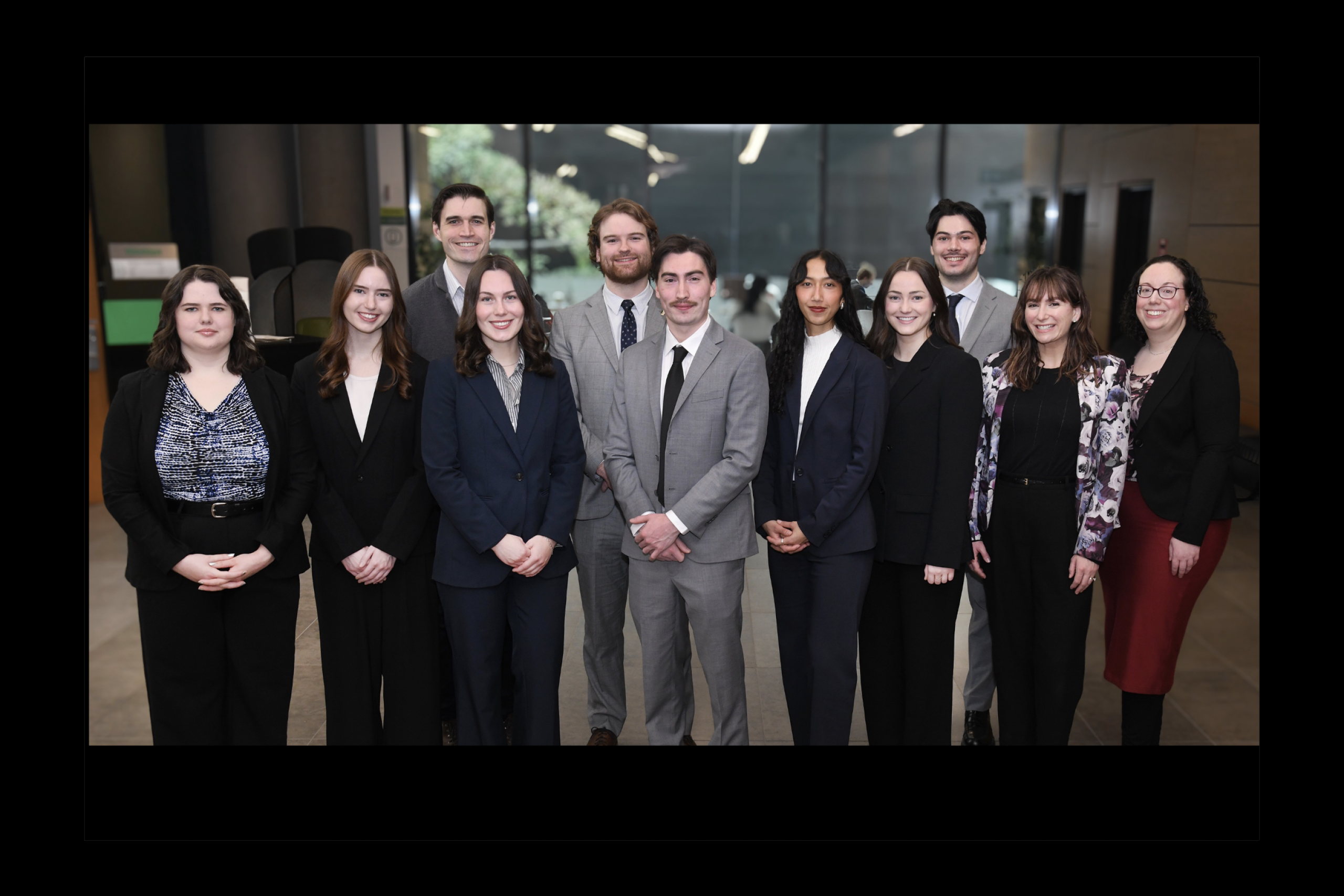 a group of law students and their coaches wear grey and black suits
