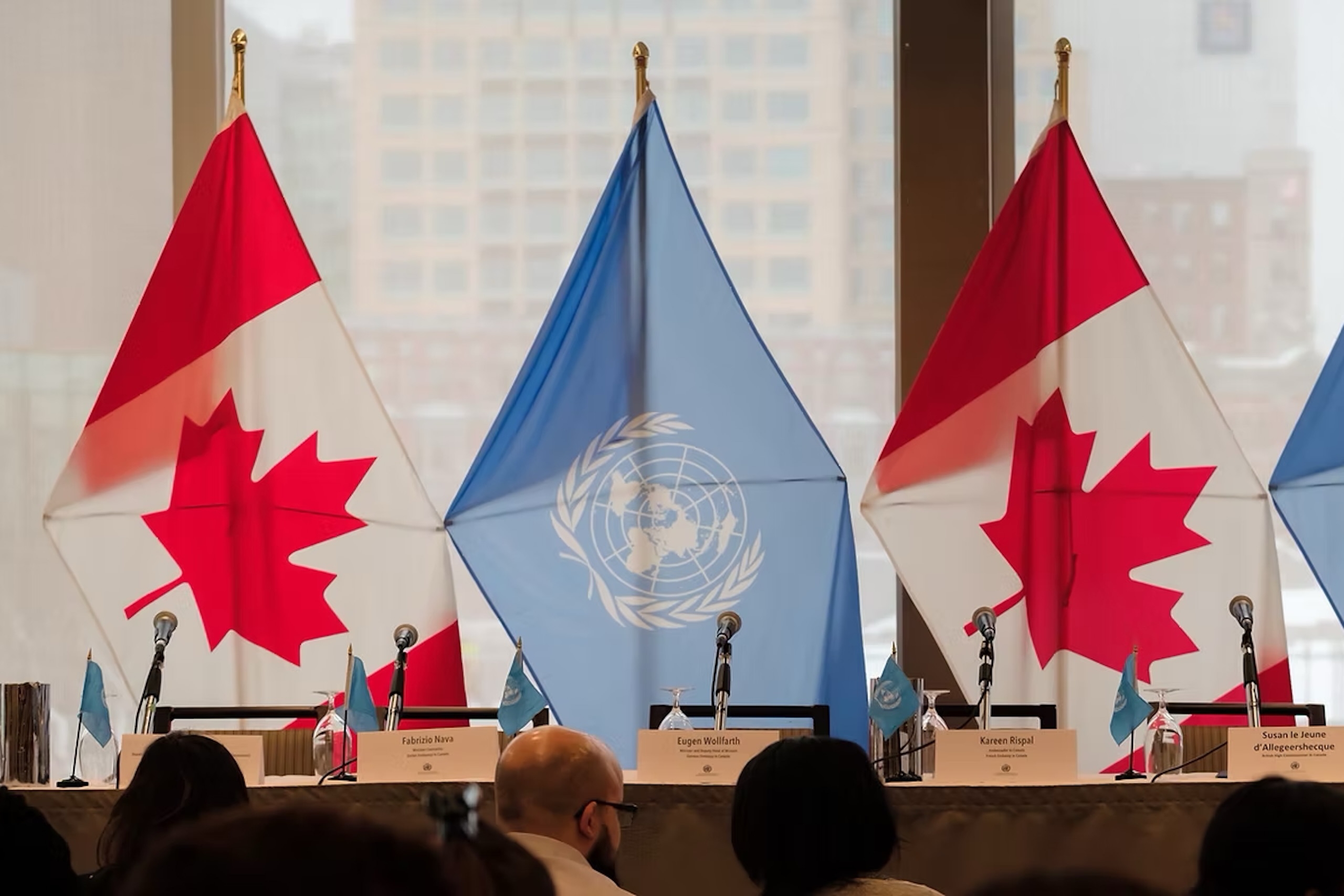 Two Canadian and 2 blue United Nations flags.