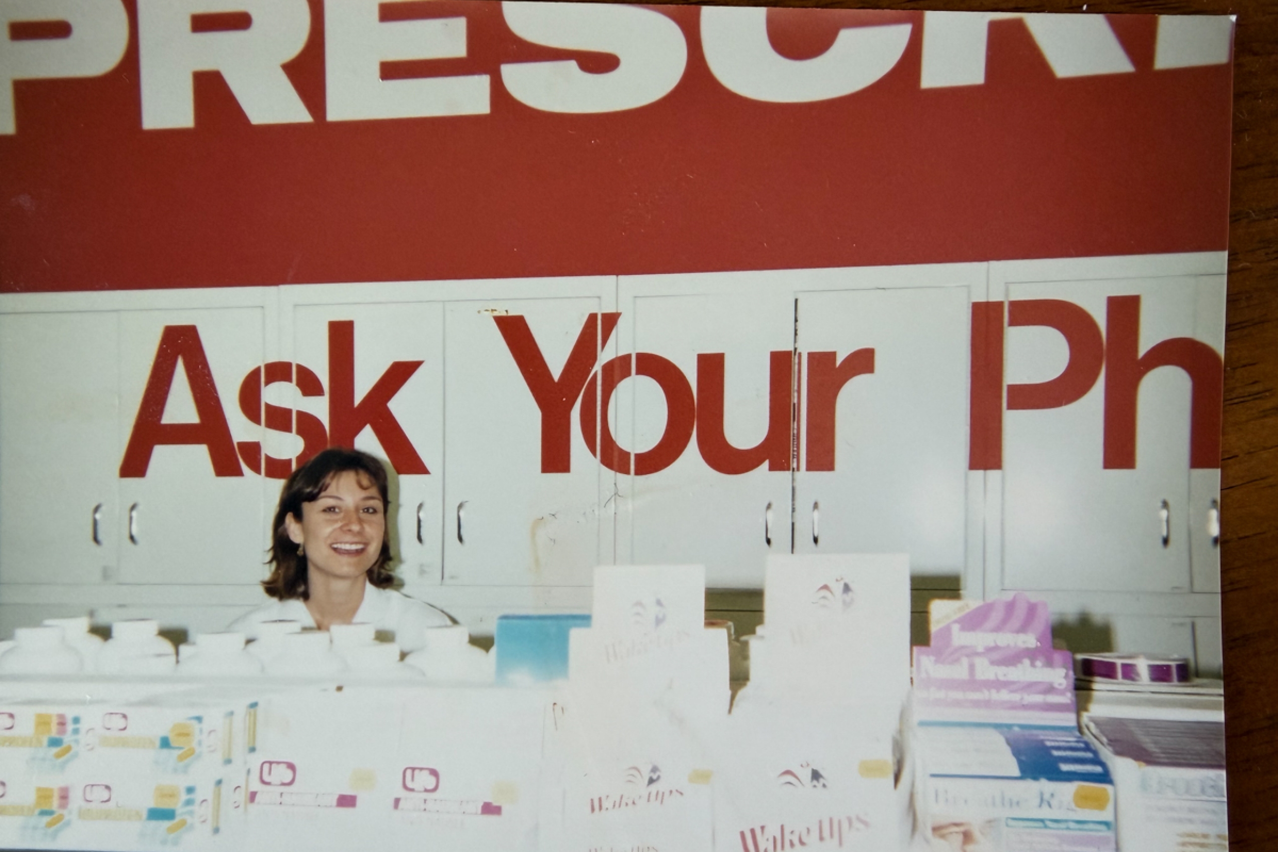 Pharmacist behind a counter in a drugstore.