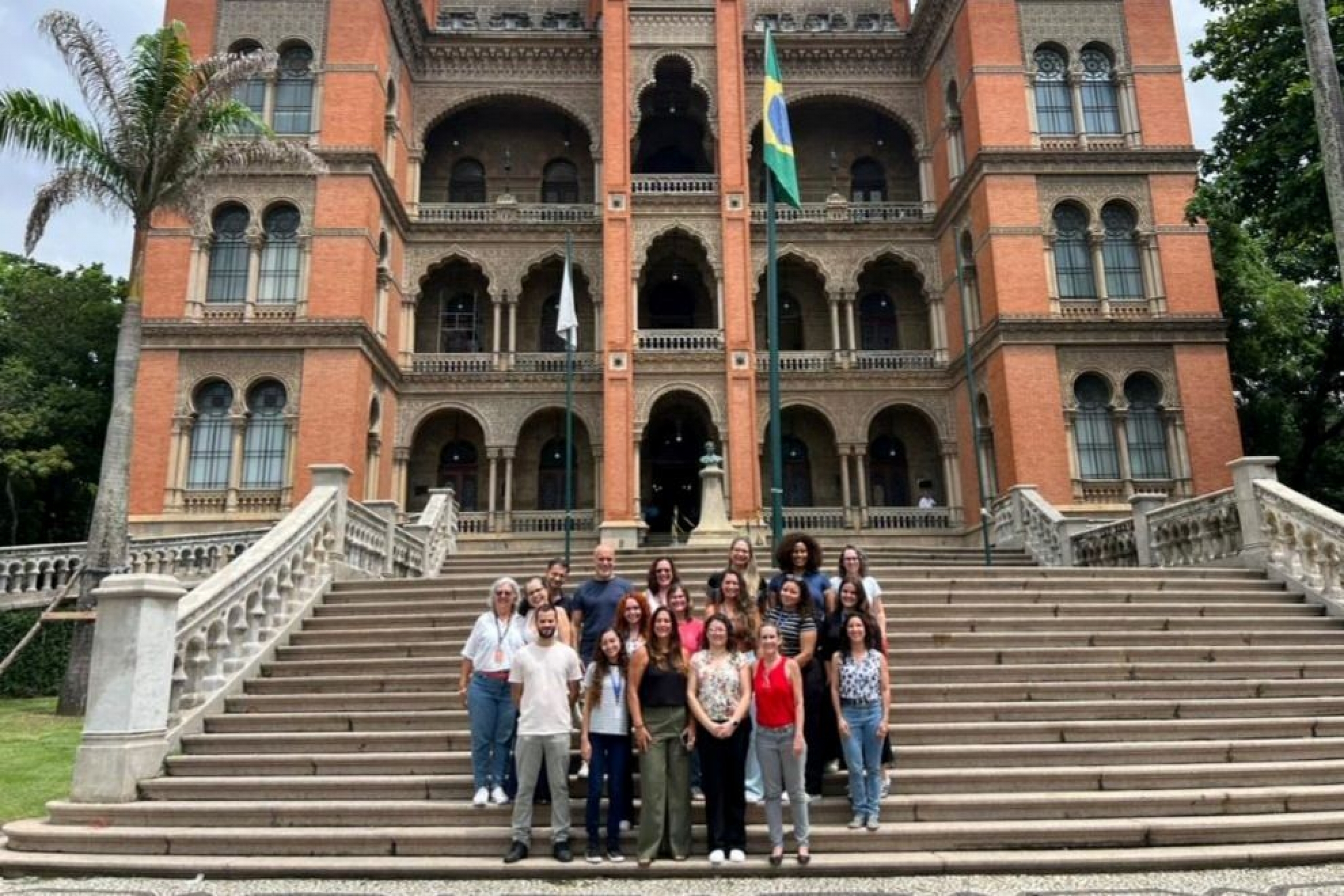 A group of people stand on the steps of a historic building in Rio de Janeiro.