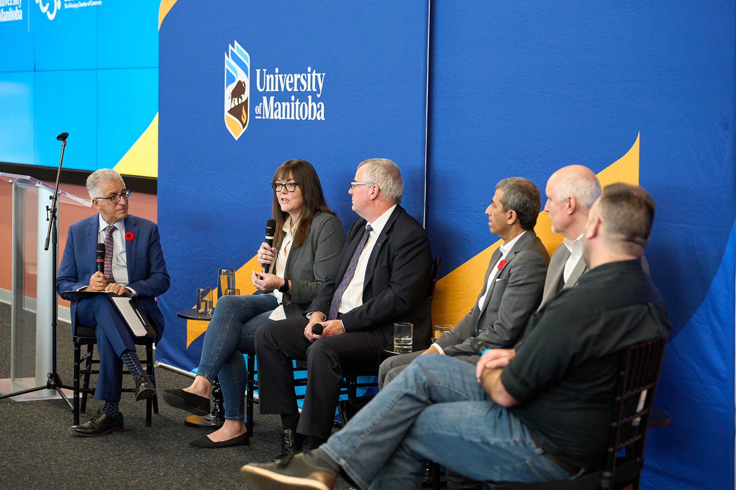 A panel including moderator Michael Benarroch and panelists Jessica Floresco, Bruno Dyck, Ash Modha, Dan Overall, and Sean Hogan