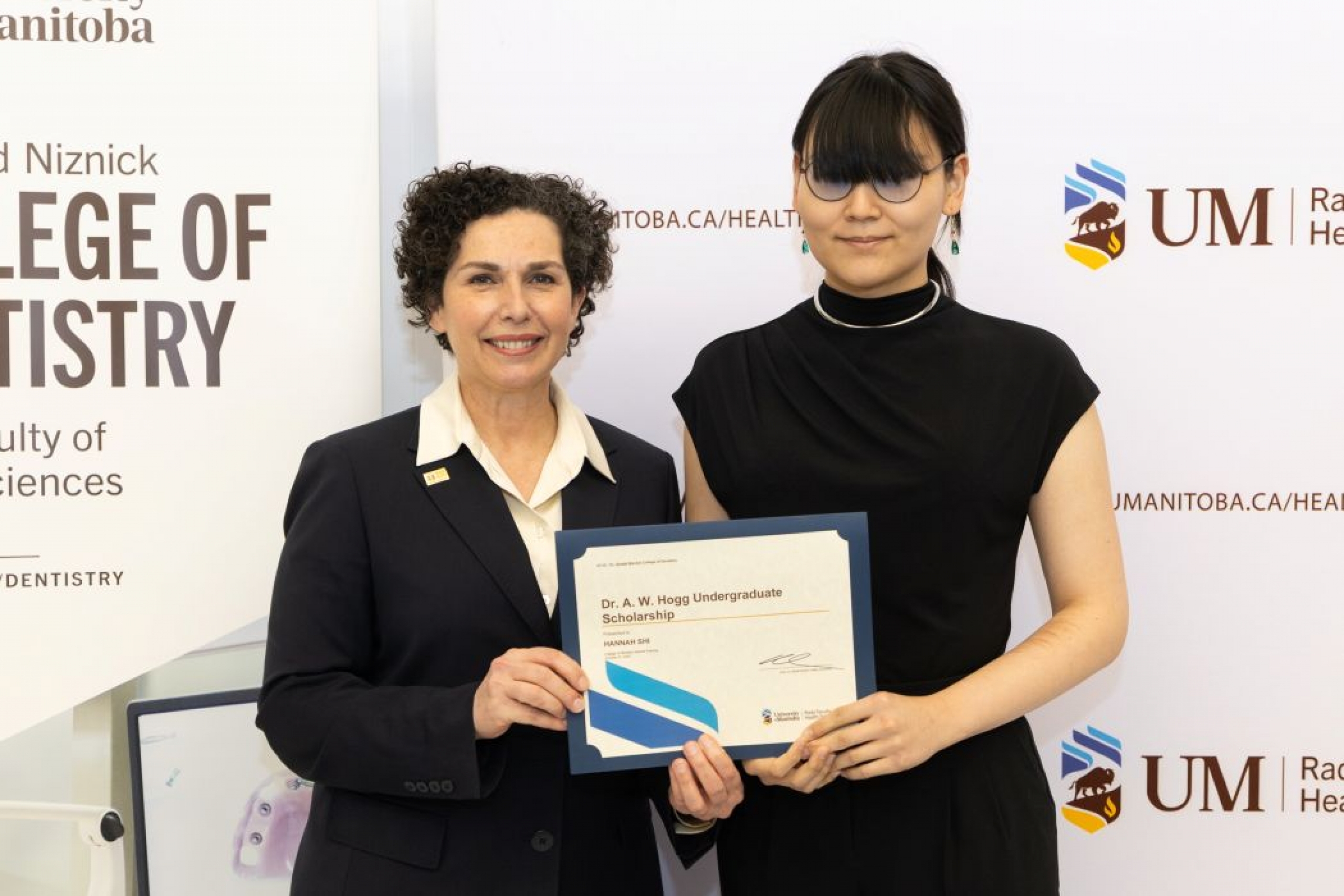 One person presents a certificate to another person.