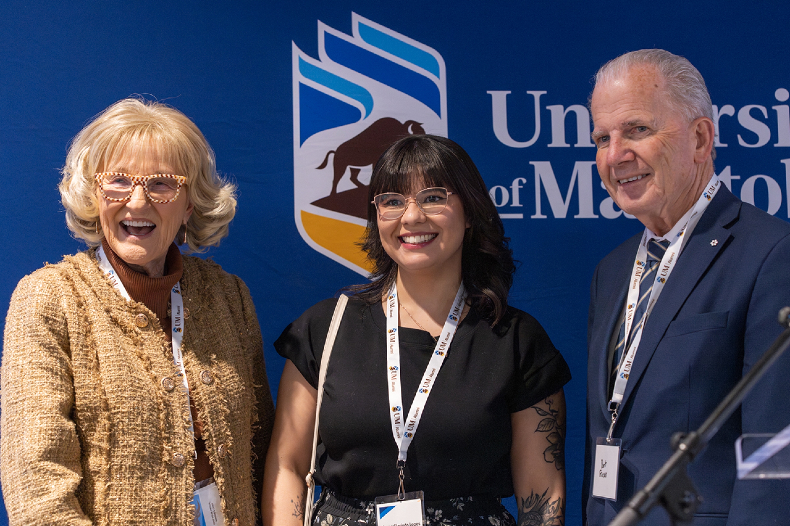 a student posing with two donors
