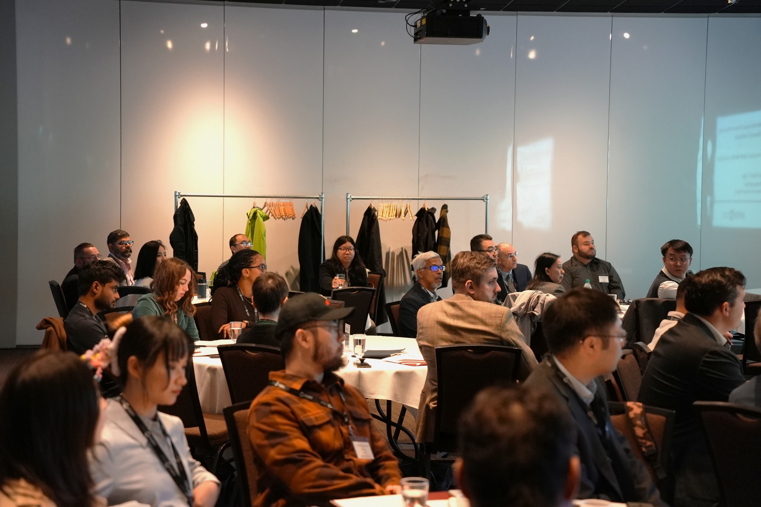 A room of people facing a speaker