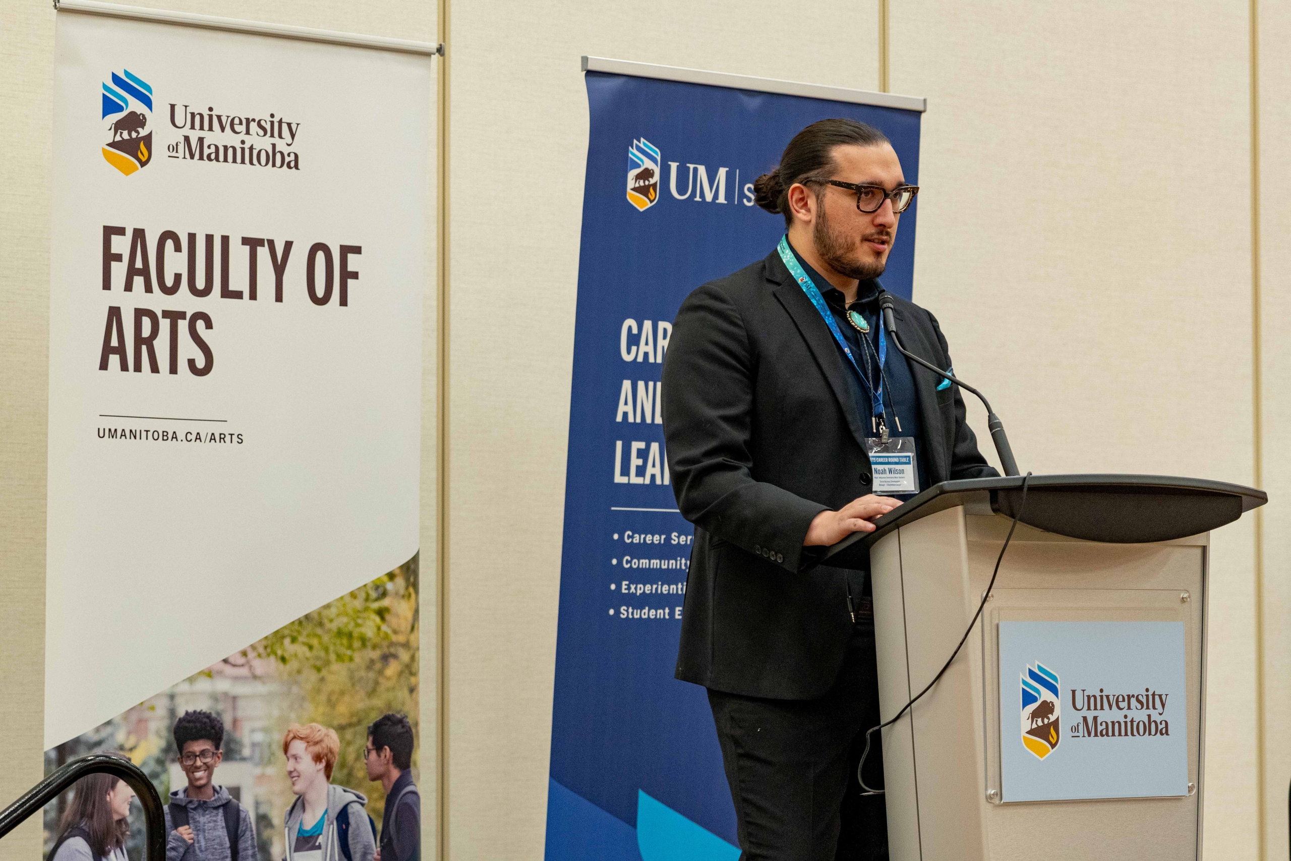 Noah Wilson presents from a podium on a stage.