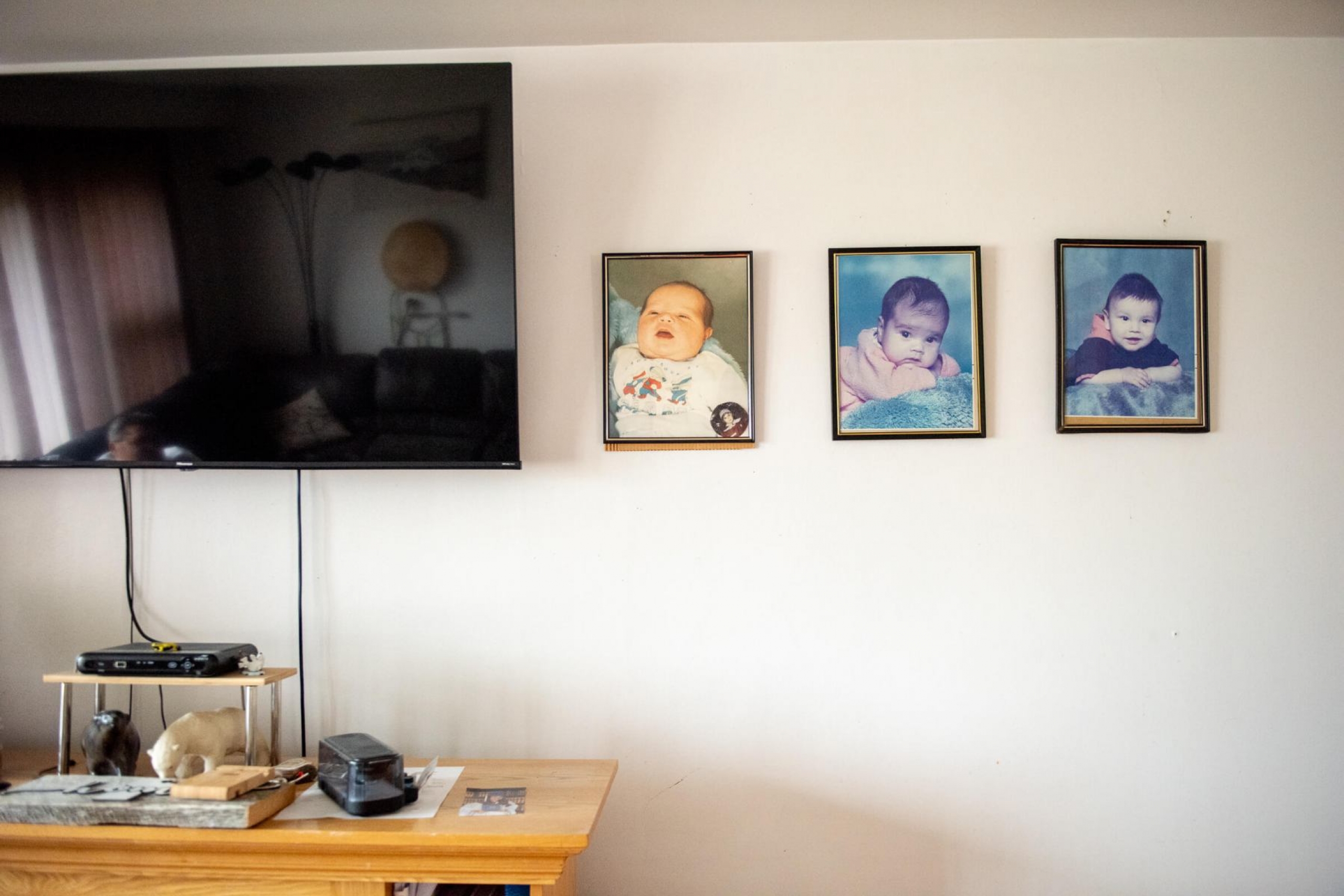 Baby photos of Antonina (centre) and her siblings hang on the wall of the Kandiurins’ living room
