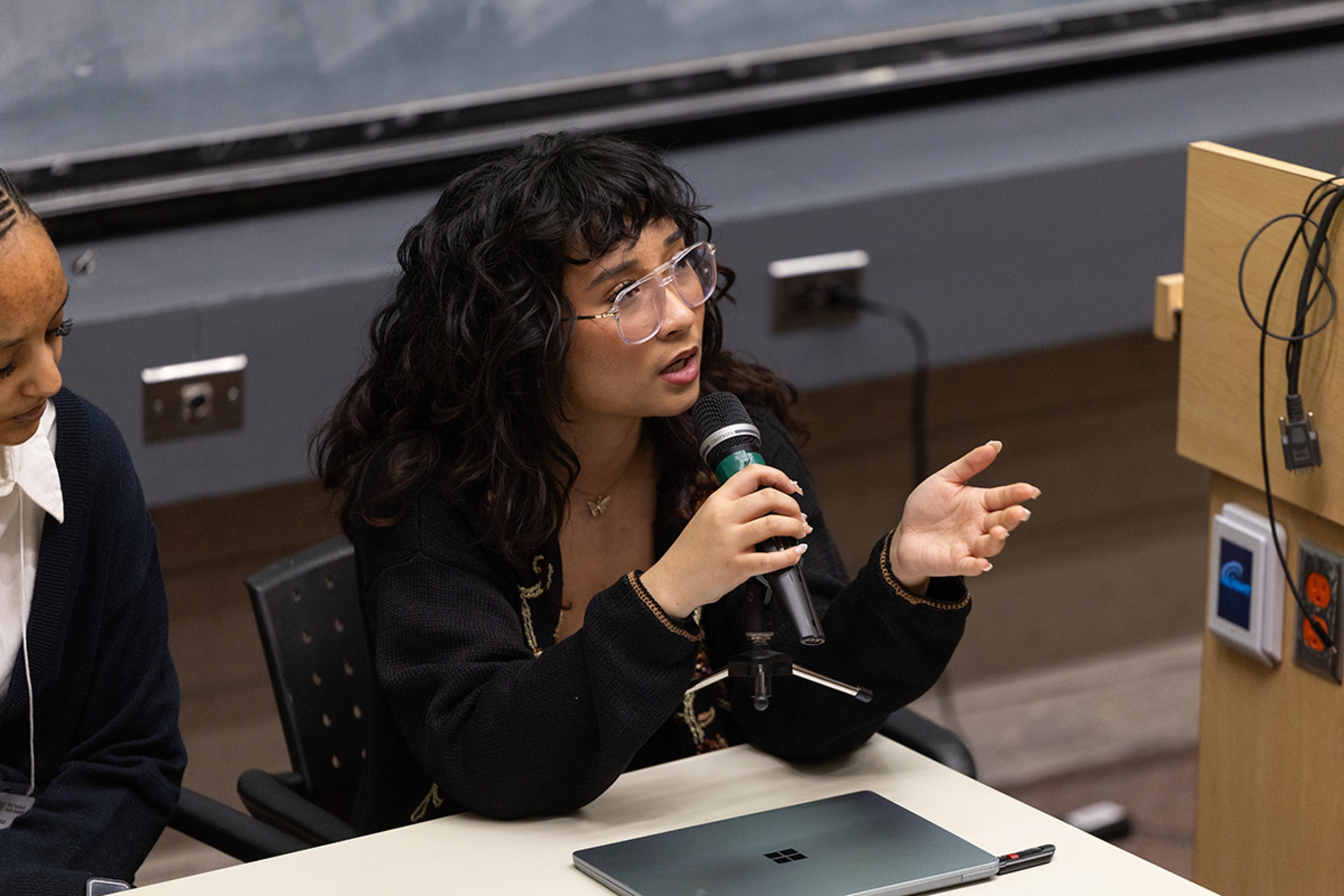 Danielle Borbajo speaks into a microphone during a panel dsicussion.