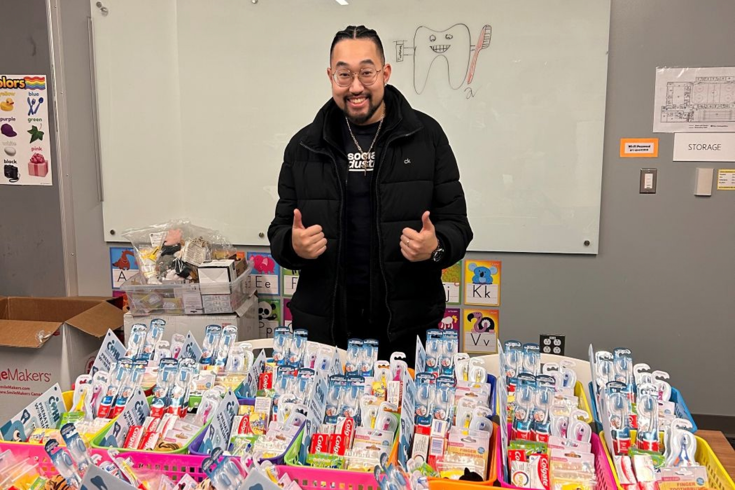 David Van stands in front of baskets of oral hygiene products. 