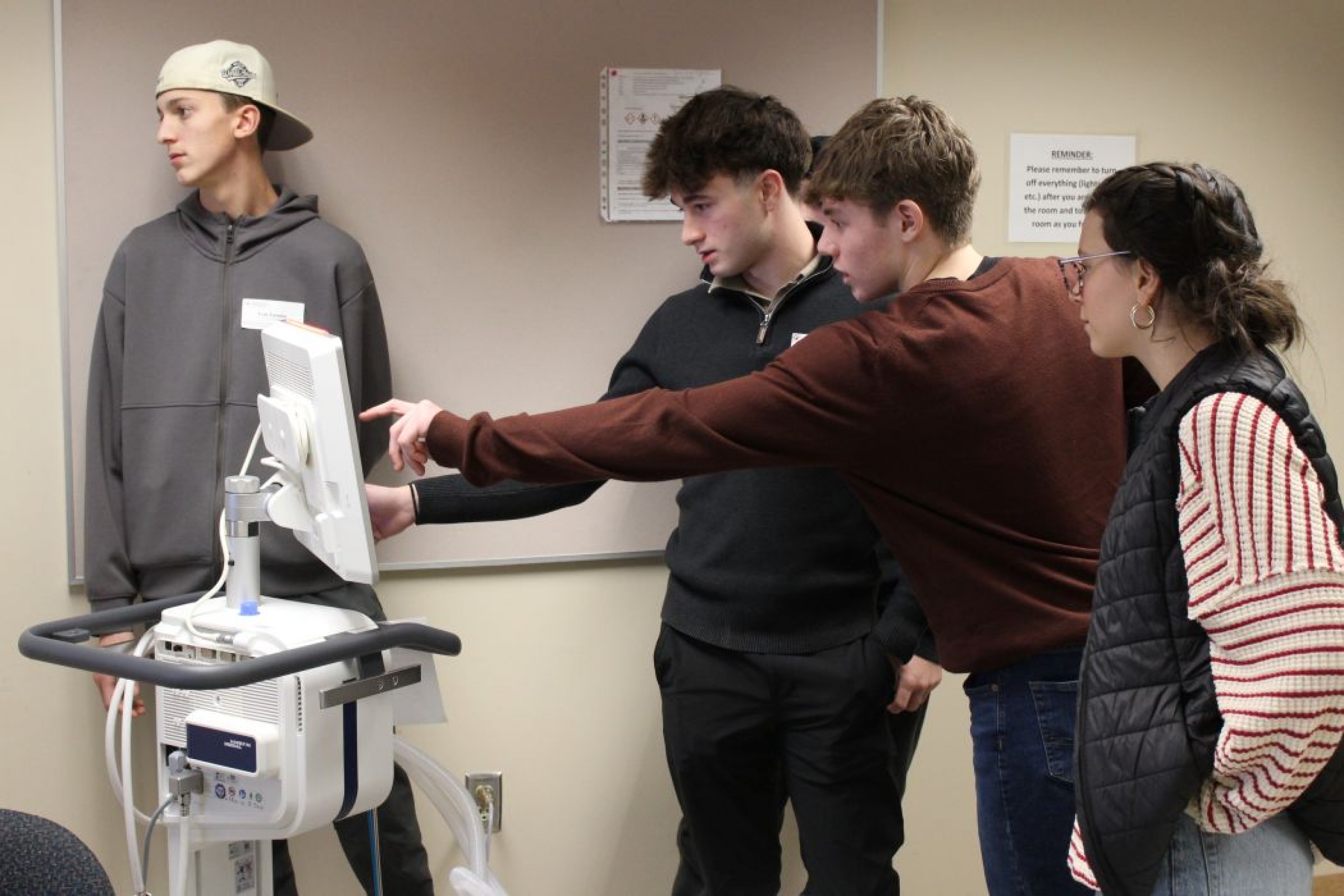 Two students point at a screen. 