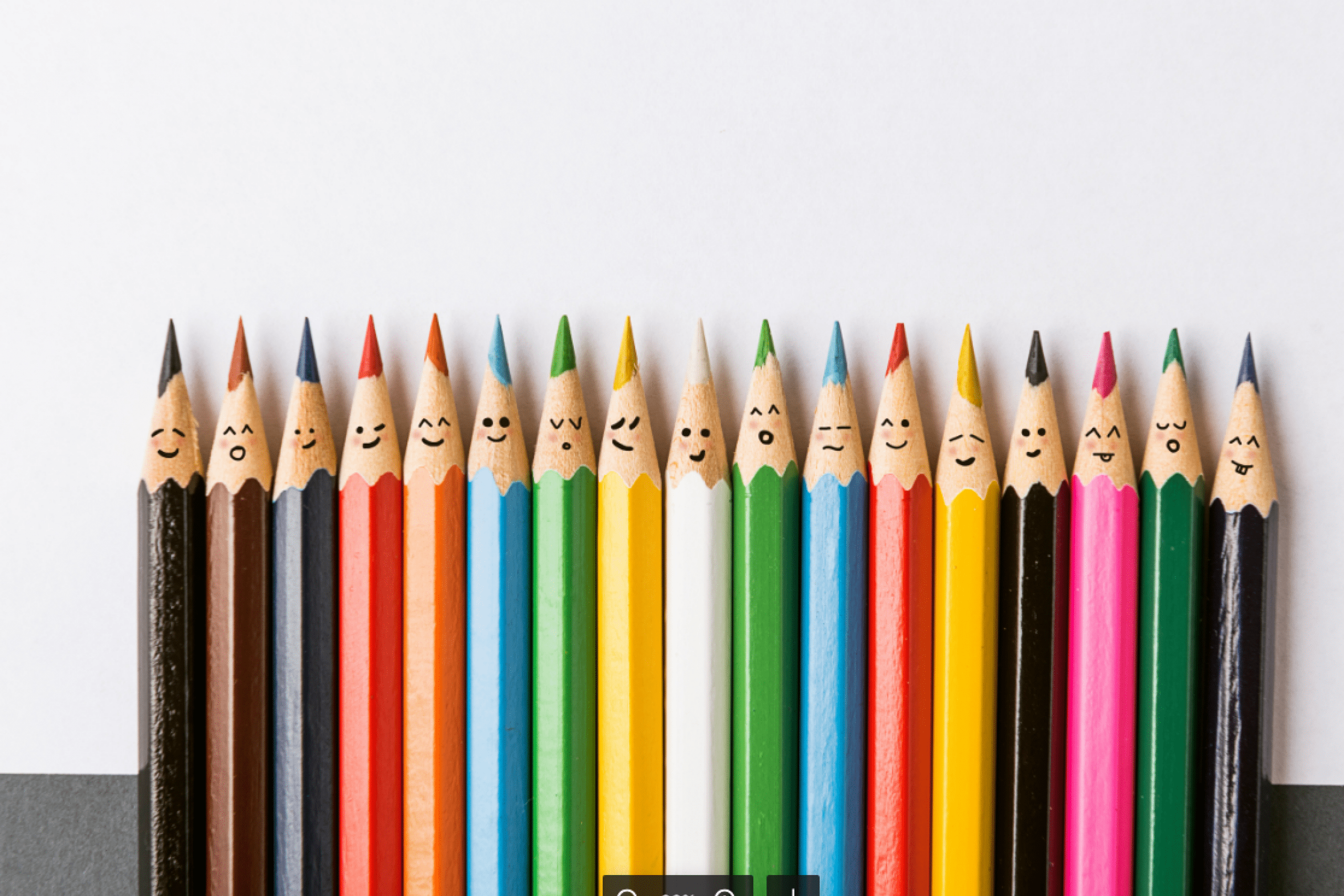 Pencils of many colours with faces