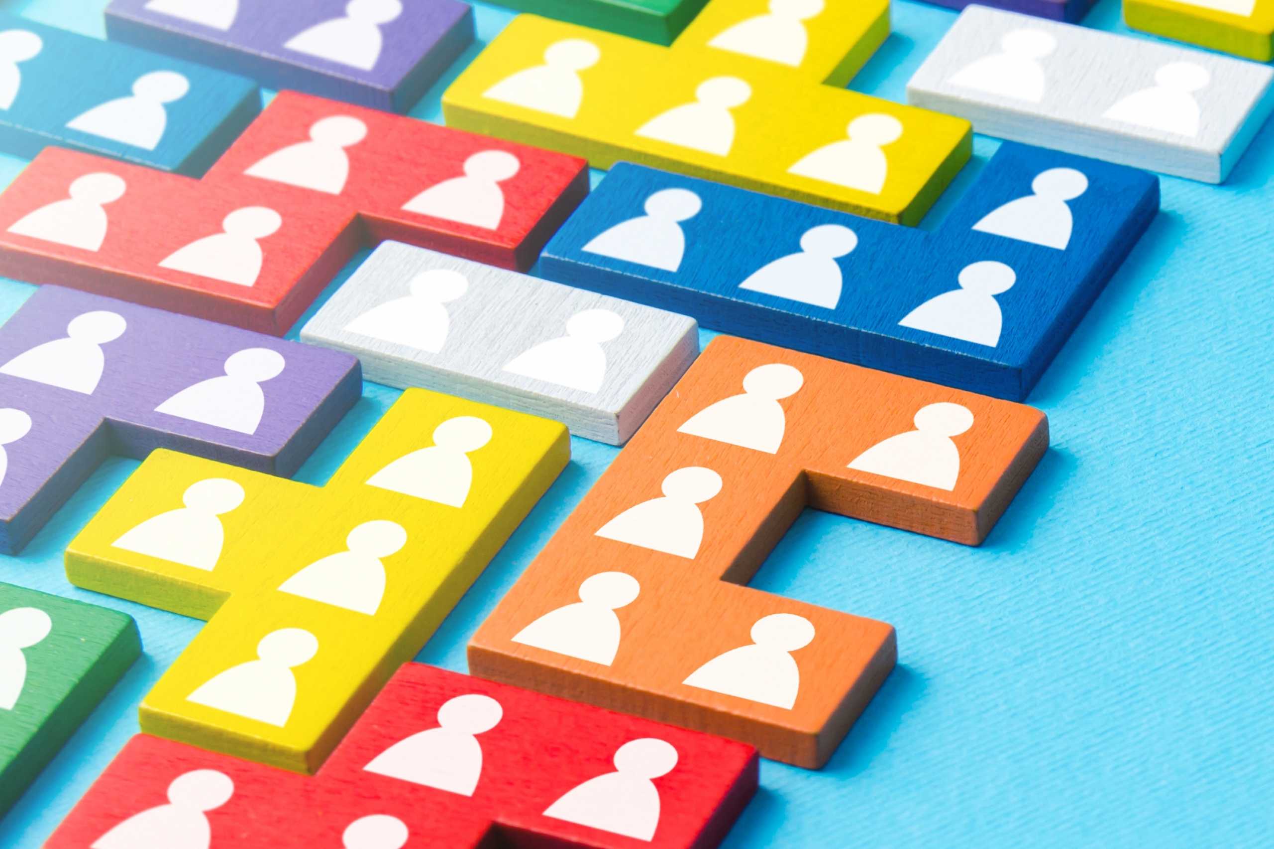 Many colours of puzzle pieces with human on them connect