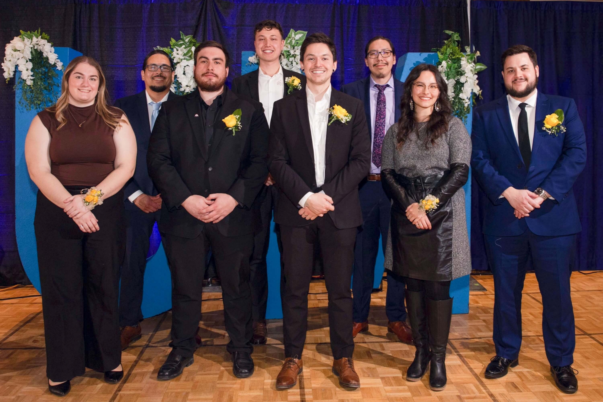 A group of people in formal wear looking at camera