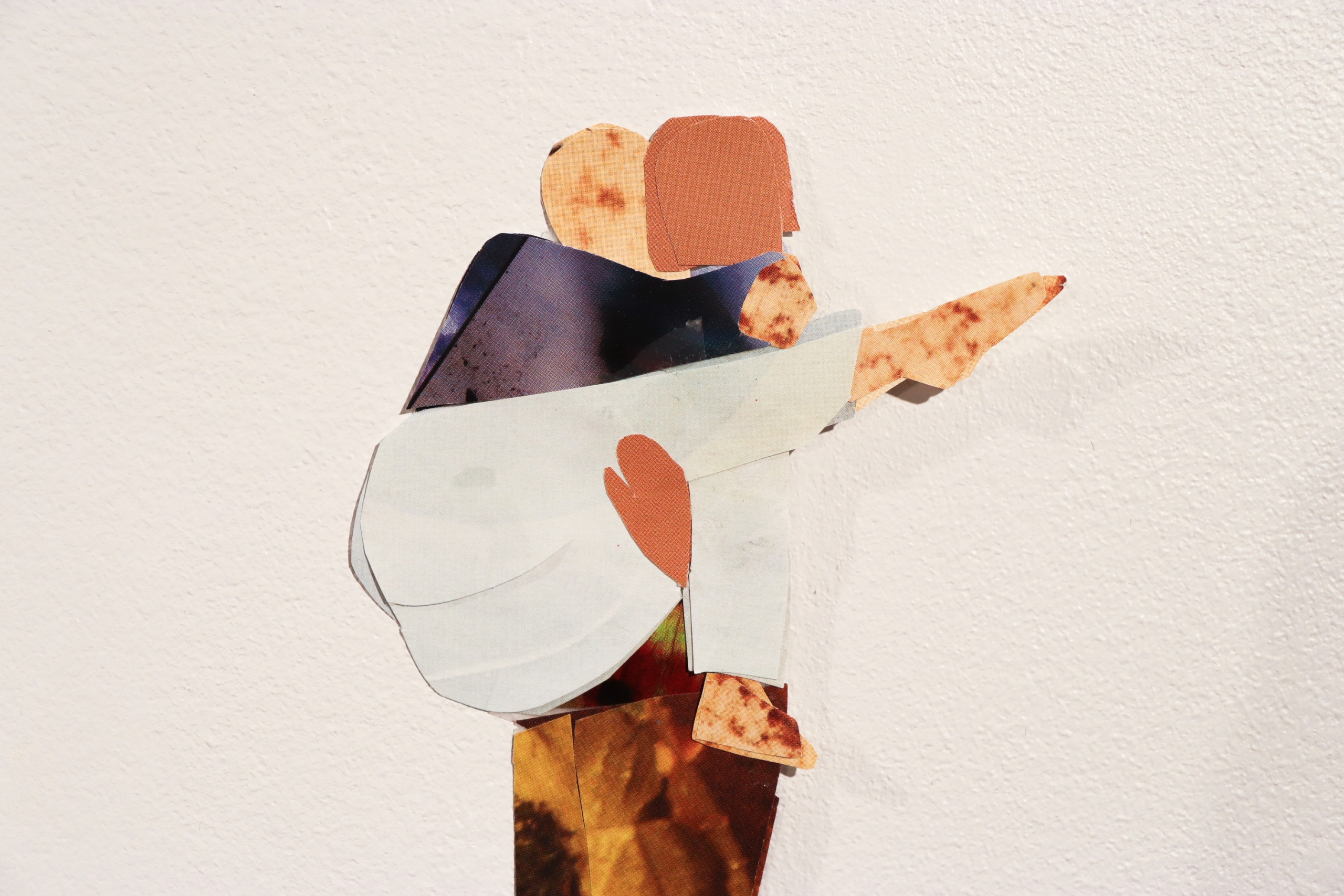 Small collage depicting two abstracted figures embracing.