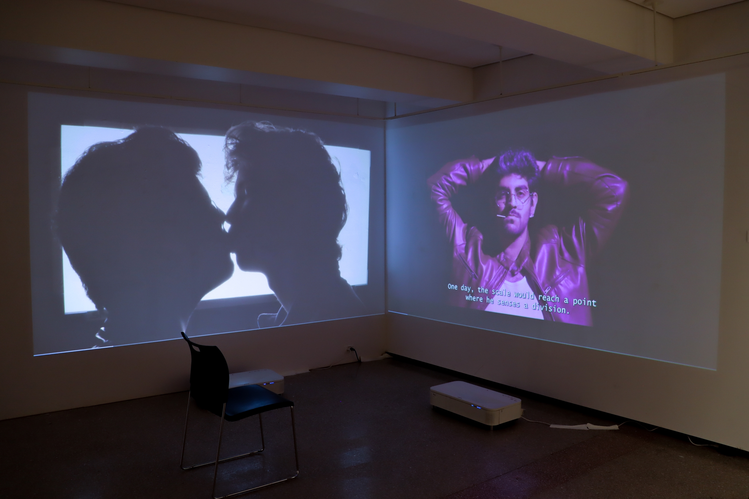 Video installation projecting queer figures and text across gallery walls.