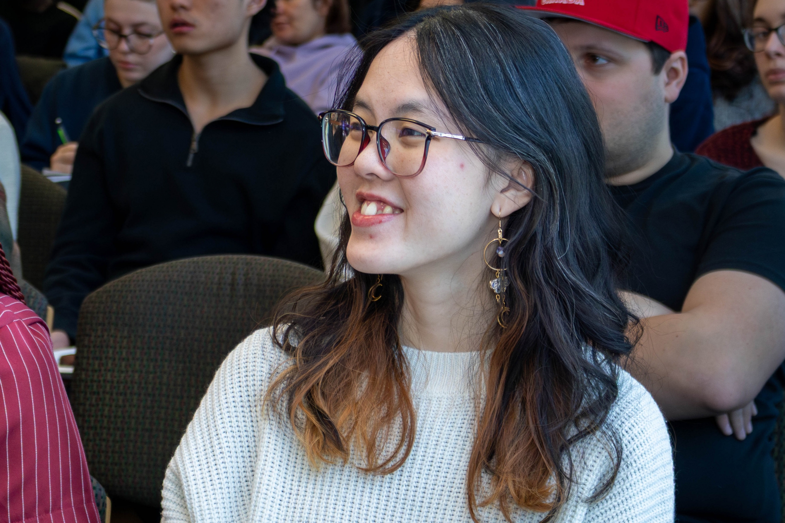 Elysa Lu watching a presentation. She is smiling. 
