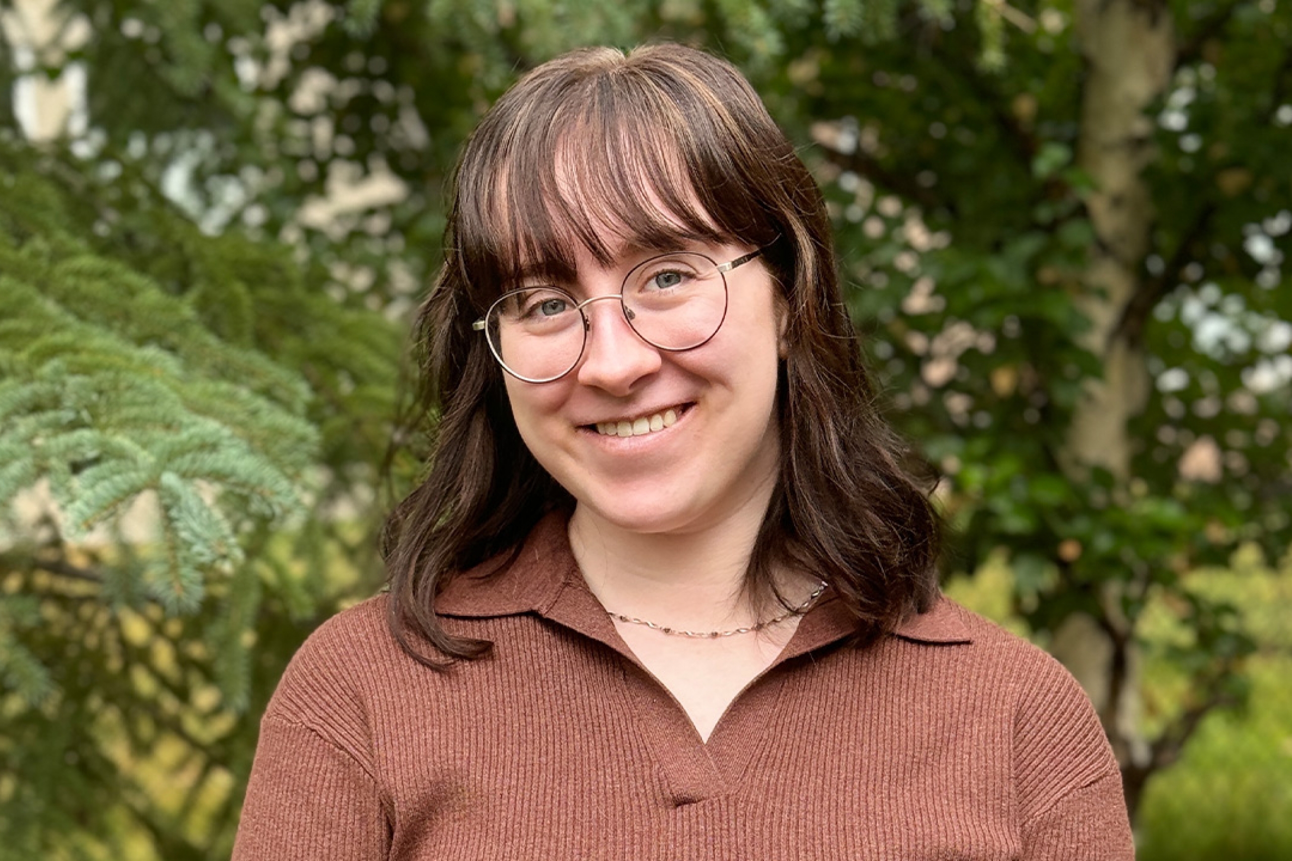 Emma Heath smiling in front of greenery outside