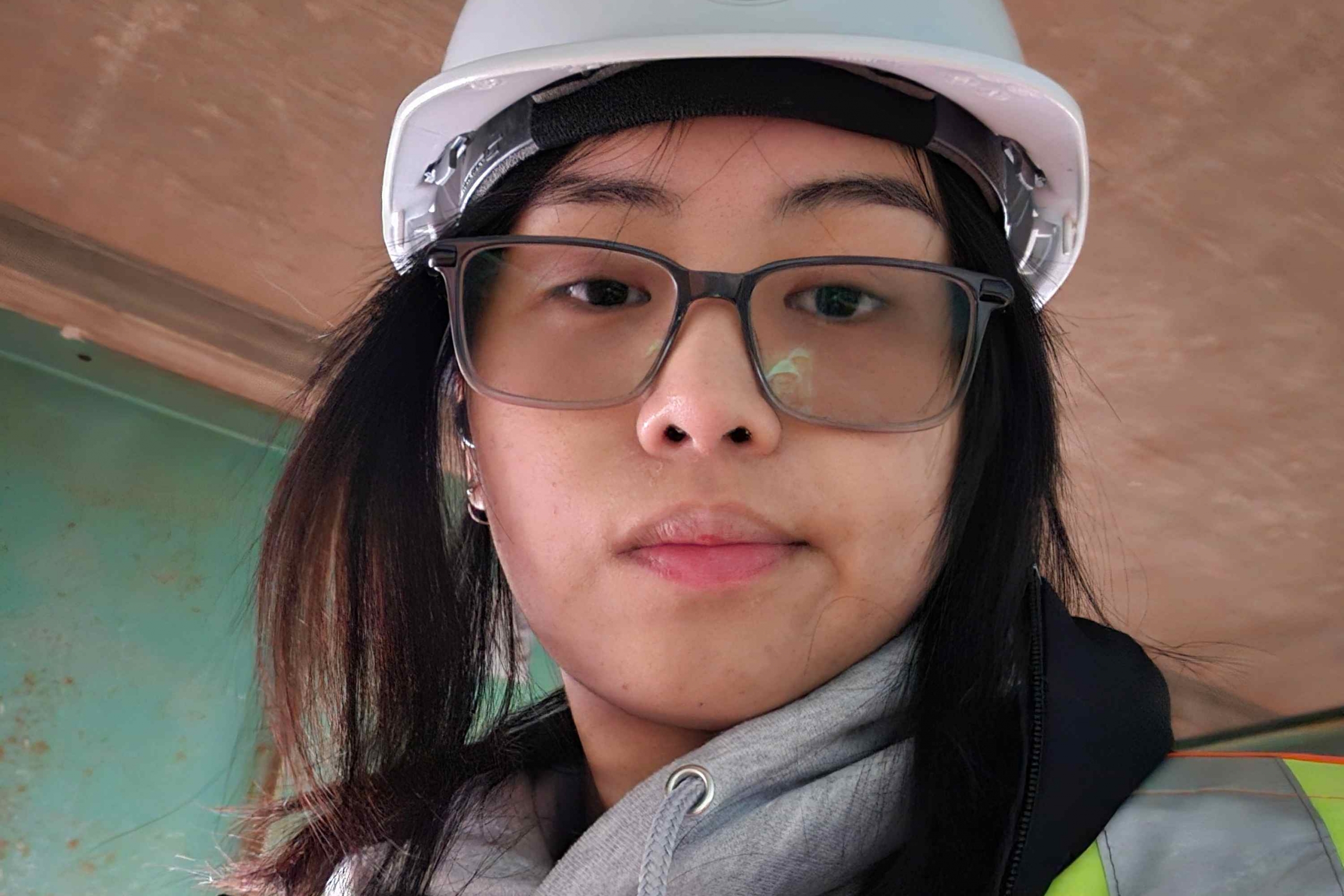 Young woman in hardhat and construction wear.